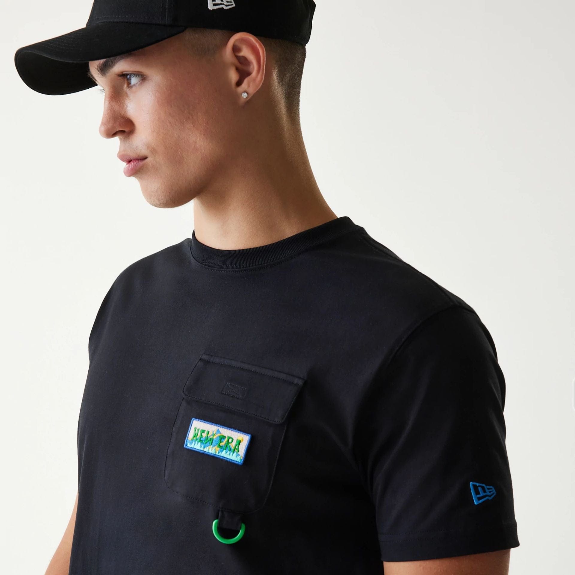 The Male model is wearing New Era Outdoor Earth Day Black Side Pocket T-Shirt 7