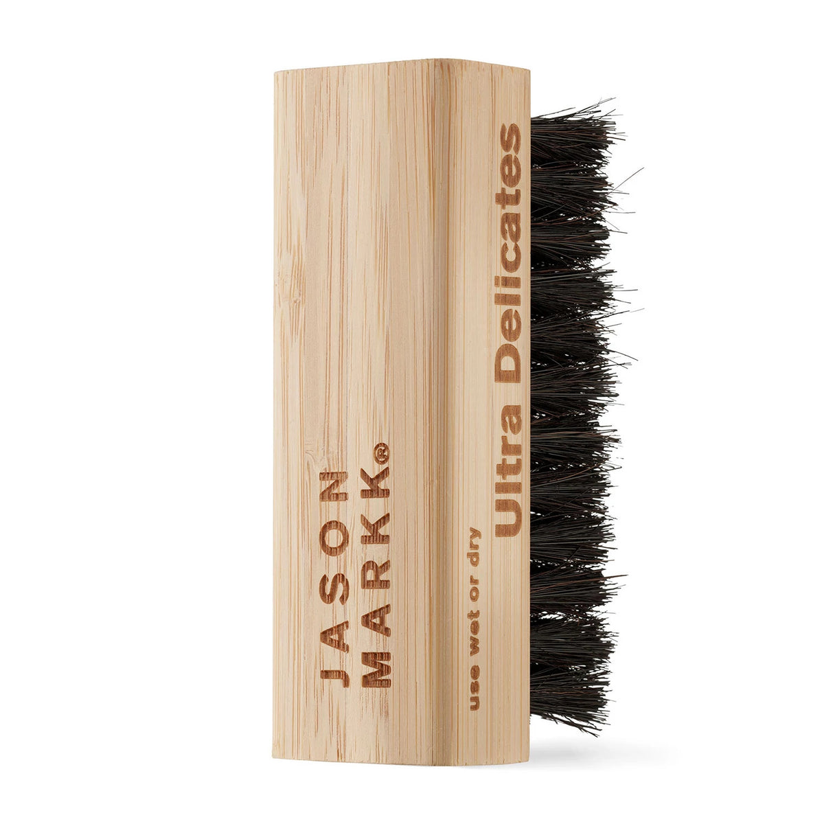 Jason Markk® Ultra Delicates Wooden Cap Brush, side view showing the engraved branding and instructions on the light wooden handle, with dense black bristles extending from the opposite side for cleaning.