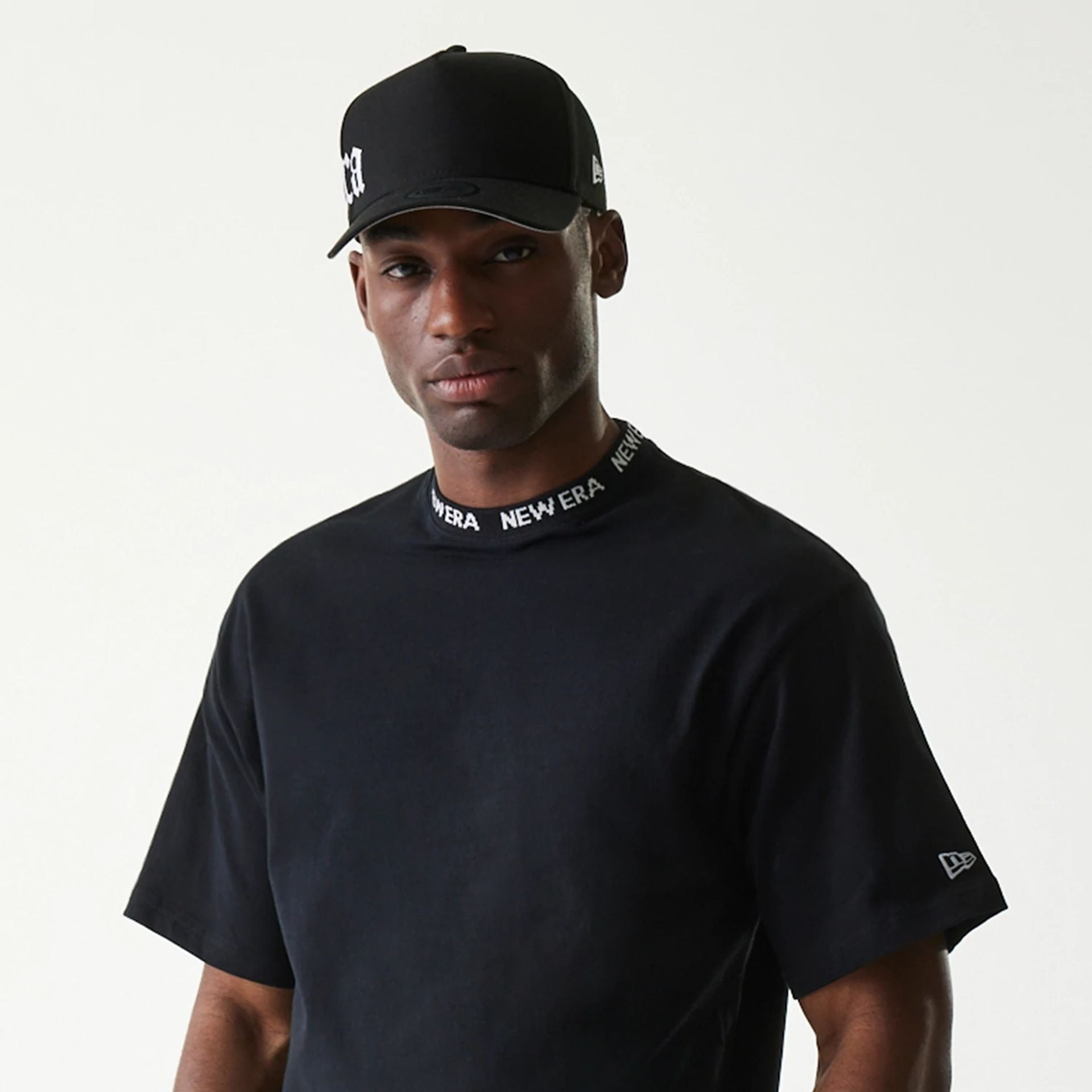 The Male model is wearing New Era Japan Neckband Logo Black T-Shirt 3