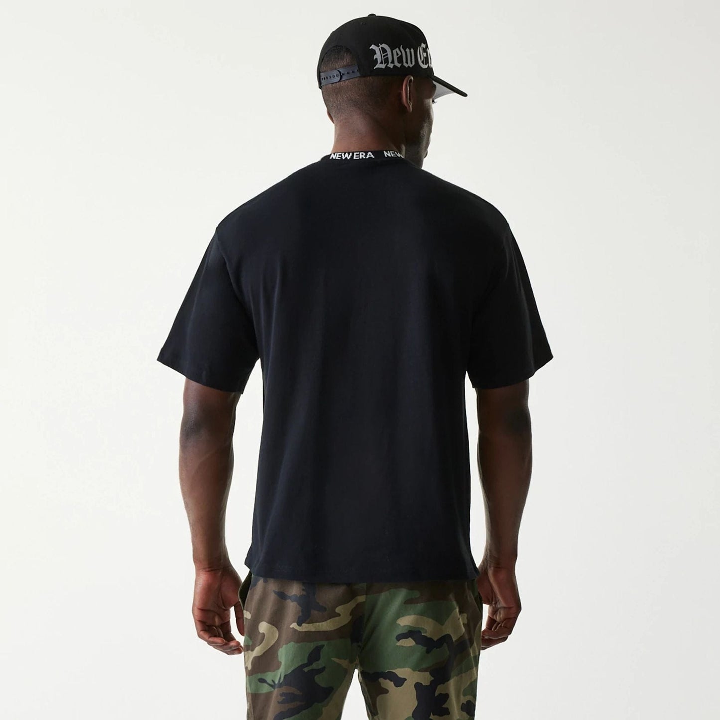 The Male model is wearing New Era Japan Neckband Logo Black T-Shirt 2