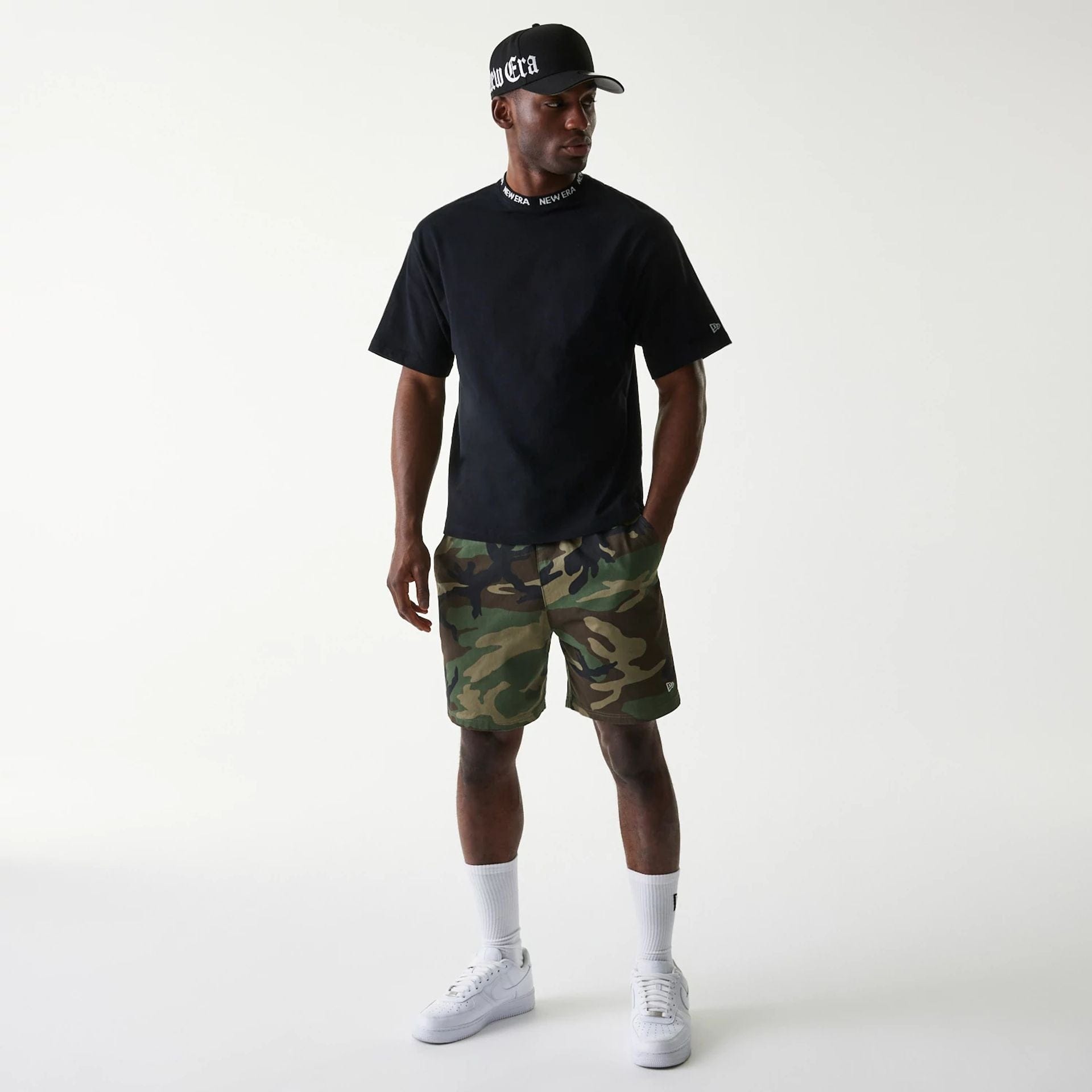 The Male model is wearing New Era Japan Neckband Logo Black T-Shirt 6