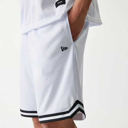 New Era Japan Mesh White Shorts, front view showing a white mesh design with a raised New Era logo on the left leg, black and white striped trim at the hem and a person's hand in the pocket.