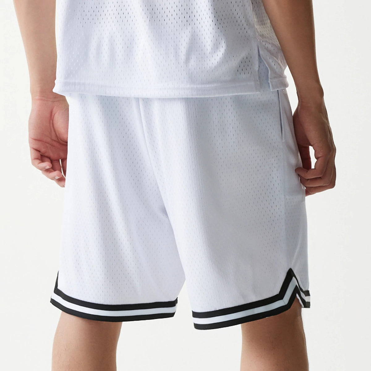 New Era Japan Mesh White Shorts, rear view showing the relaxed fit white shorts with a perforated pattern, a striped black and white trim along the hem, and flat seams on the side and back.
