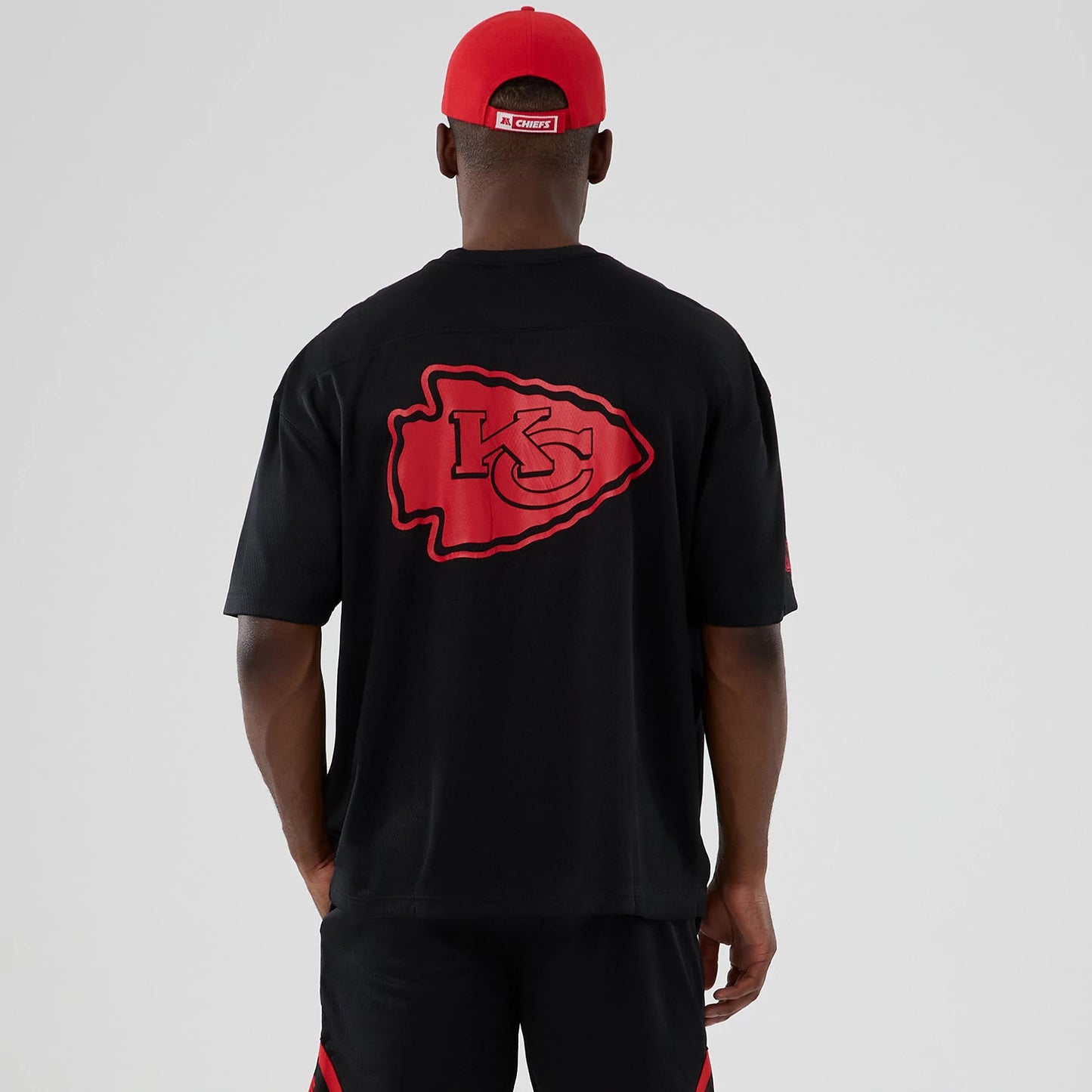 The model is wearing this NFL Historic Kansas City Chiefs Oversized T-Shirt in black. 2