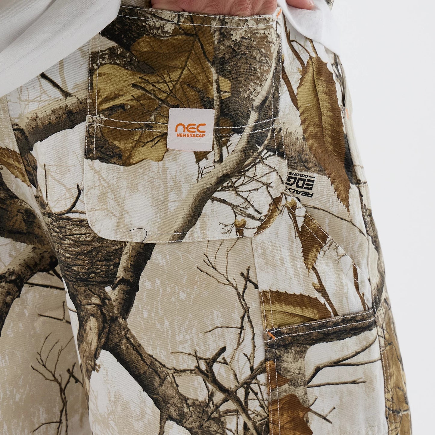 The Male model is wearing  New Era Earthy Skin Real Tree Snow Oversized Shorts 3