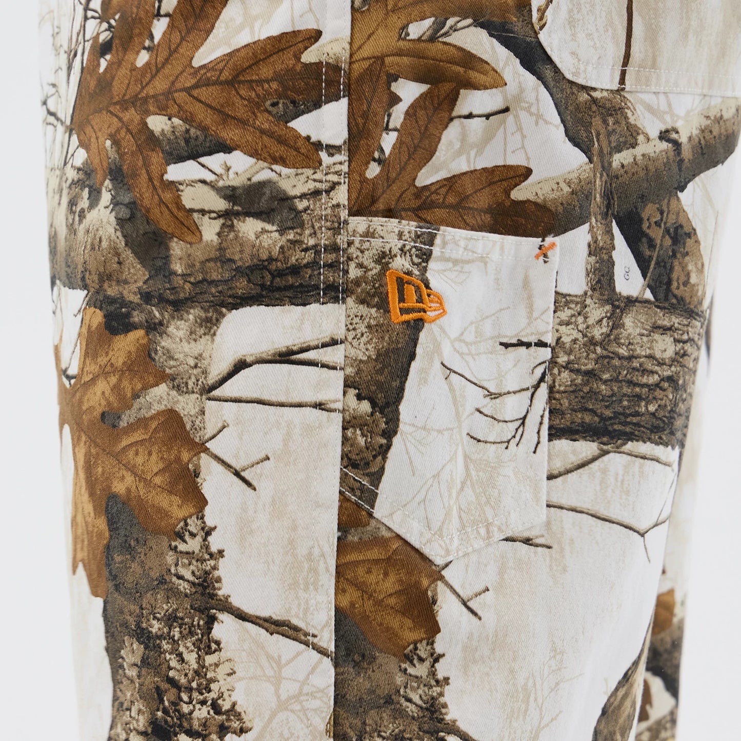The Male model is wearing  New Era Earthy Skin Real Tree Snow Oversized Shorts 4
