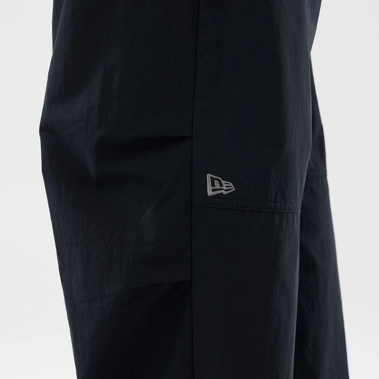 The Male model is wearing New Era Organic Black Parachute Trousers 4