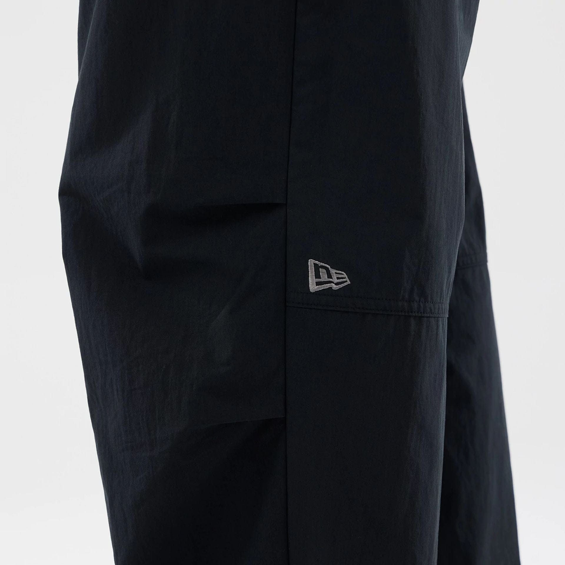 The Male model is wearing New Era Organic Black Parachute Trousers 4