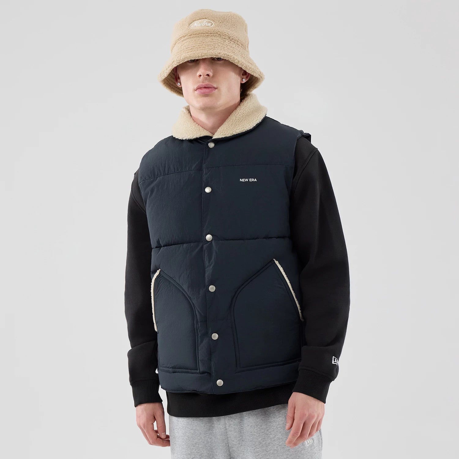 The Male model is wearing  New Era Organic Boa Neck Navy Gilet 3