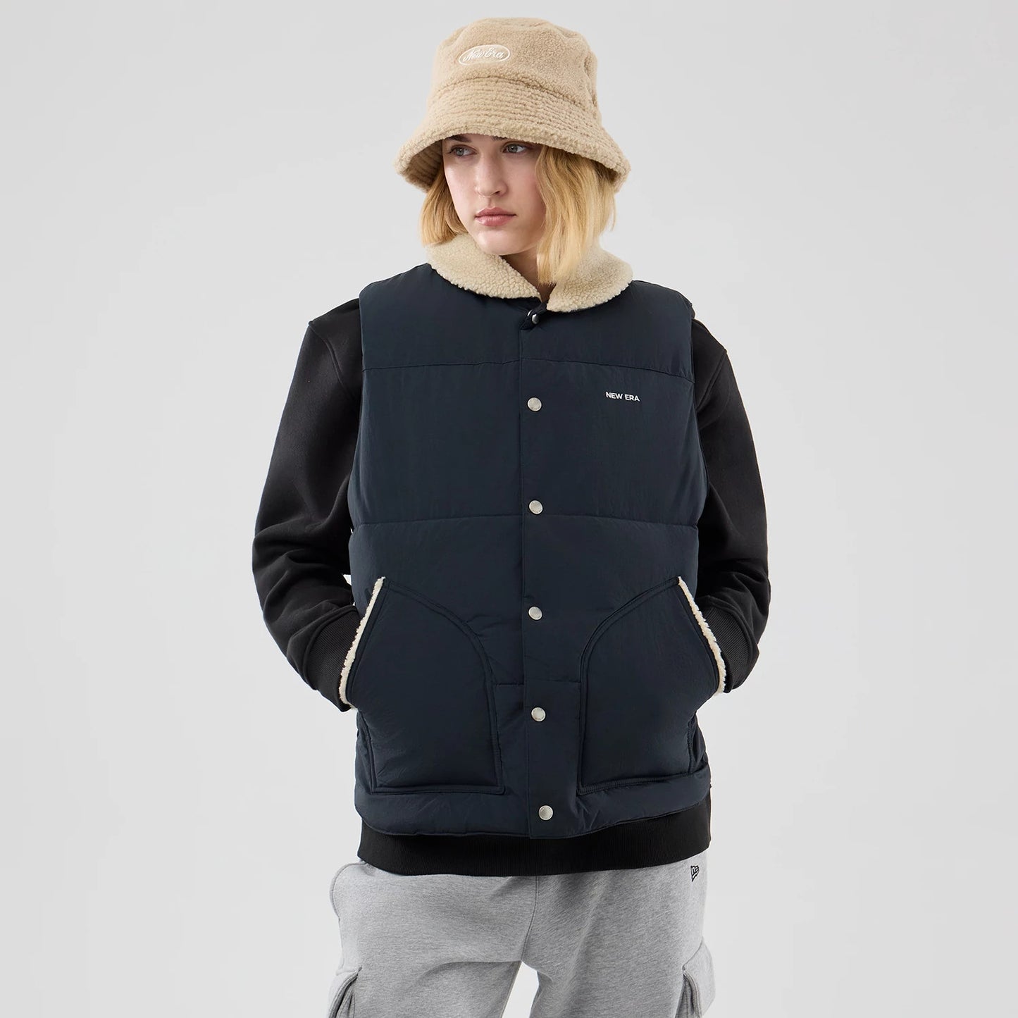 The Male model is wearing  New Era Organic Boa Neck Navy Gilet 4