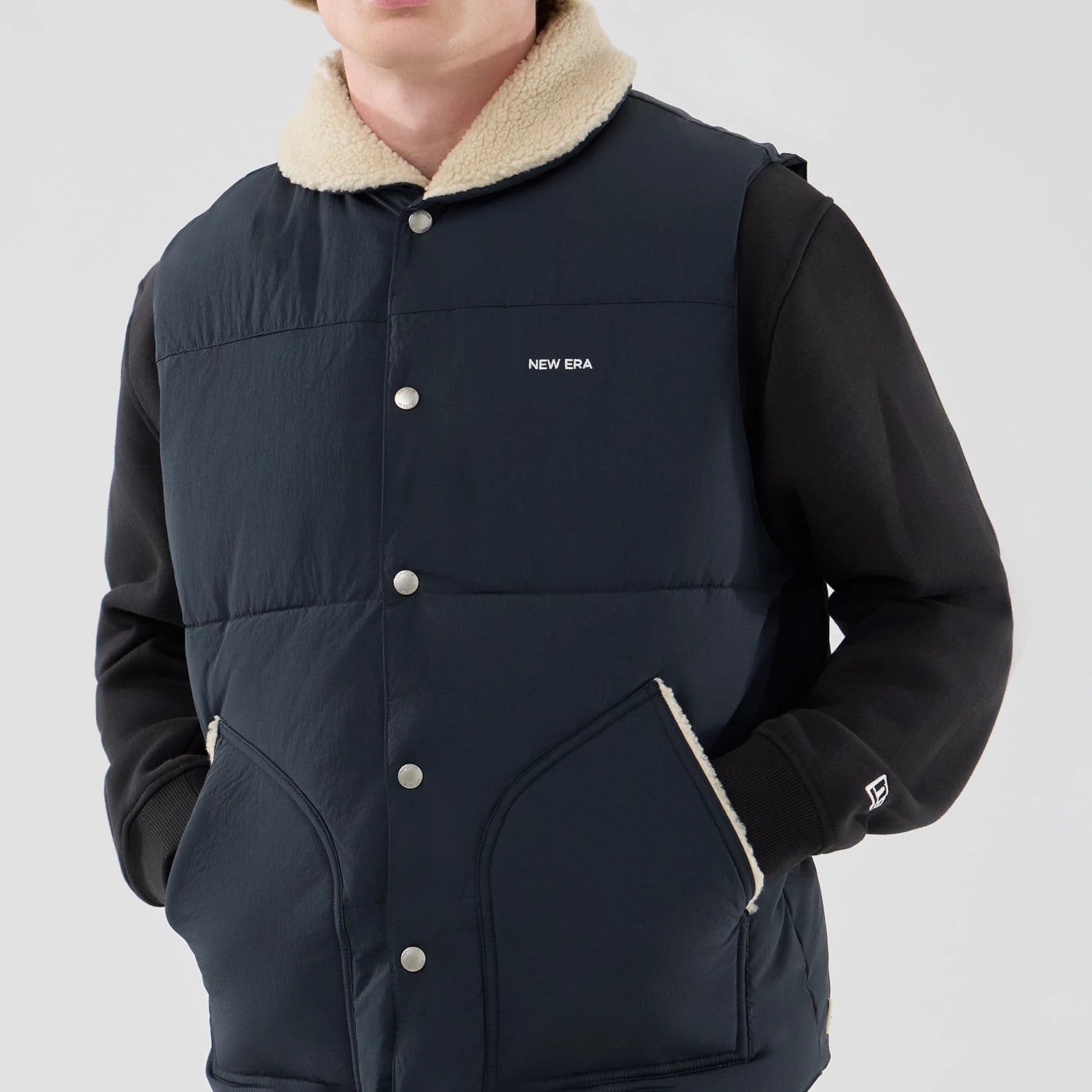 The Male model is wearing  New Era Organic Boa Neck Navy Gilet 5