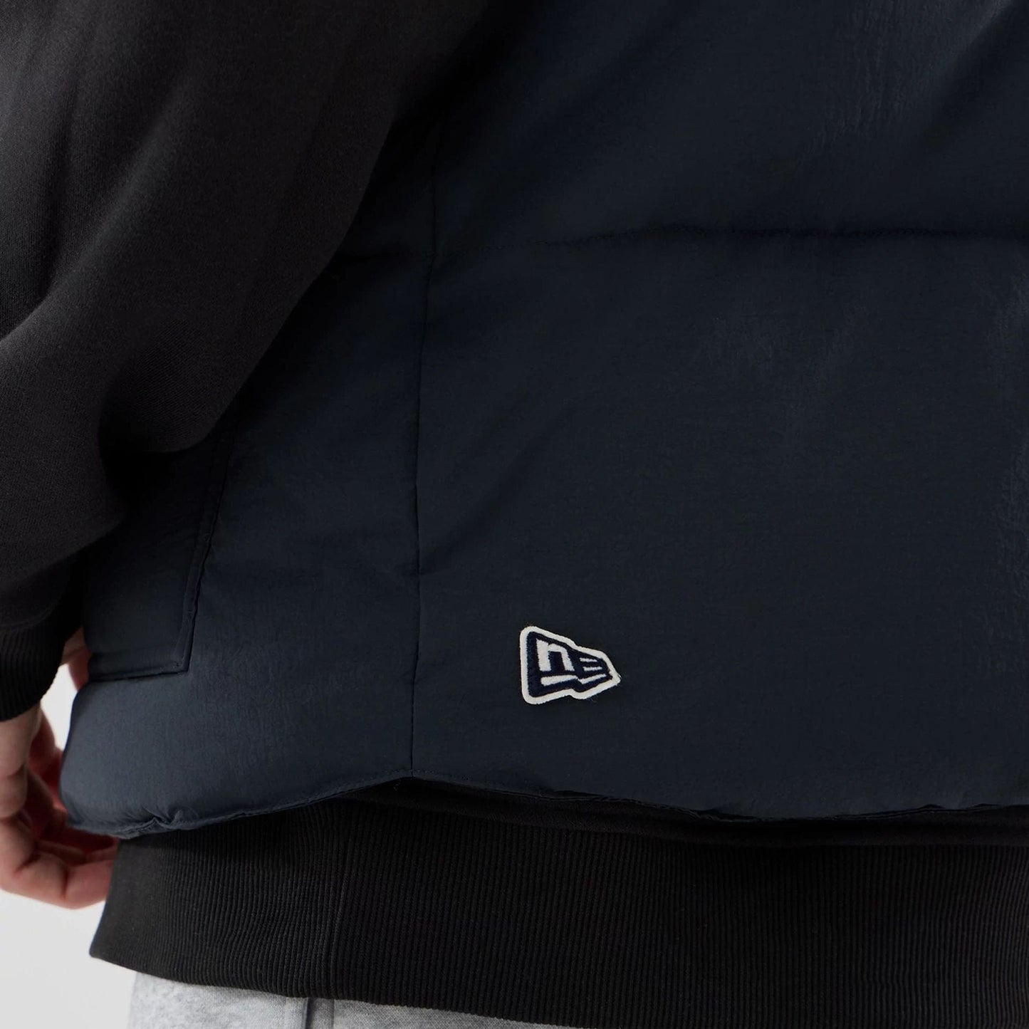 The Male model is wearing  New Era Organic Boa Neck Navy Gilet  7