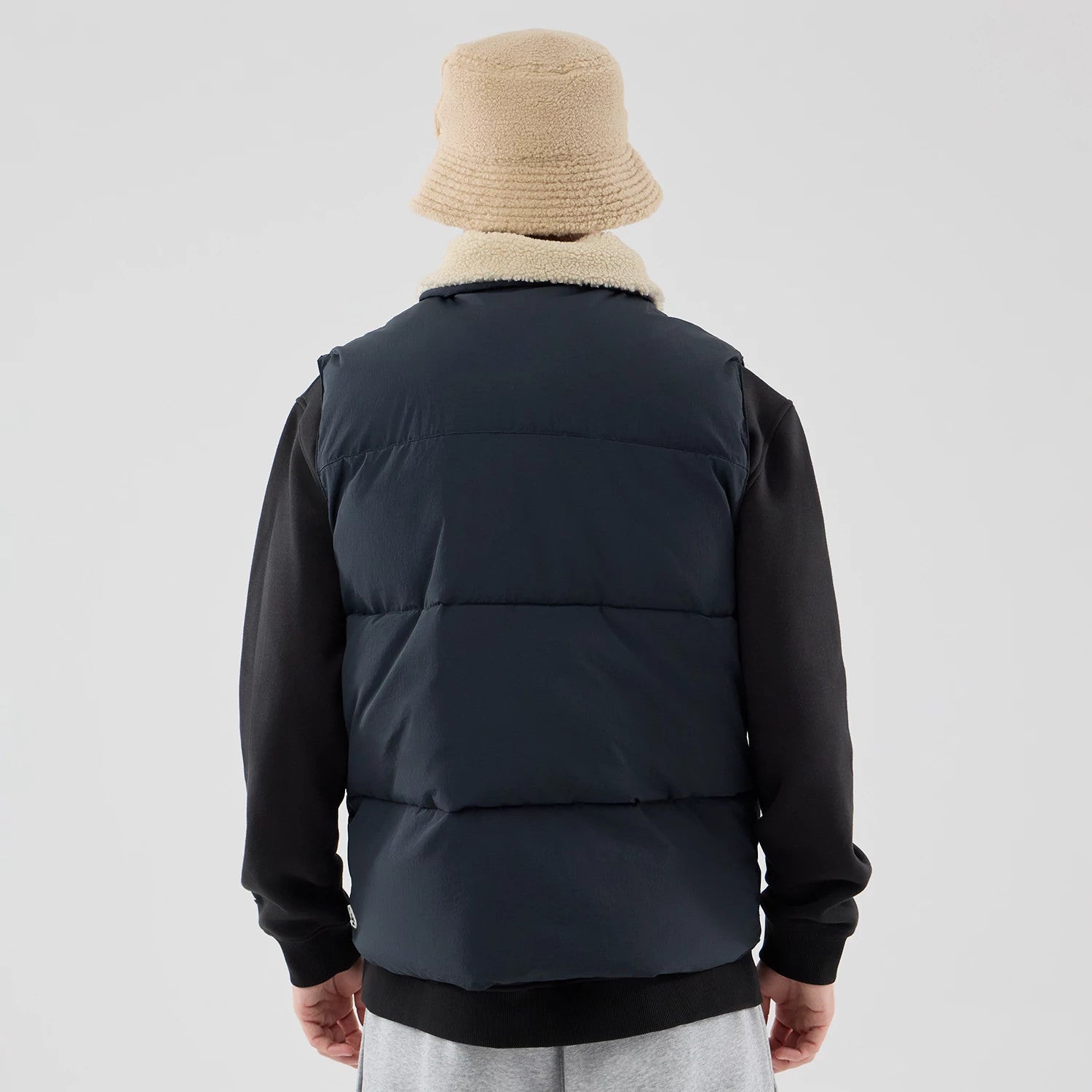 The Male model is wearing  New Era Organic Boa Neck Navy Gilet 2