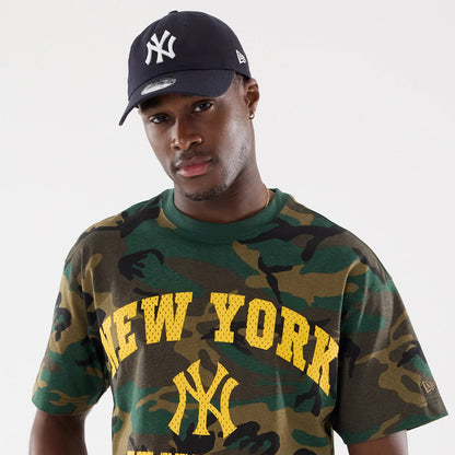 New York Yankees MLB Camo Woodland T-Shirt, on-model view showing the green and brown camouflage pattern with large yellow New York text and Yankees logo on the chest, a debossed New Era logo on the left sleeve.