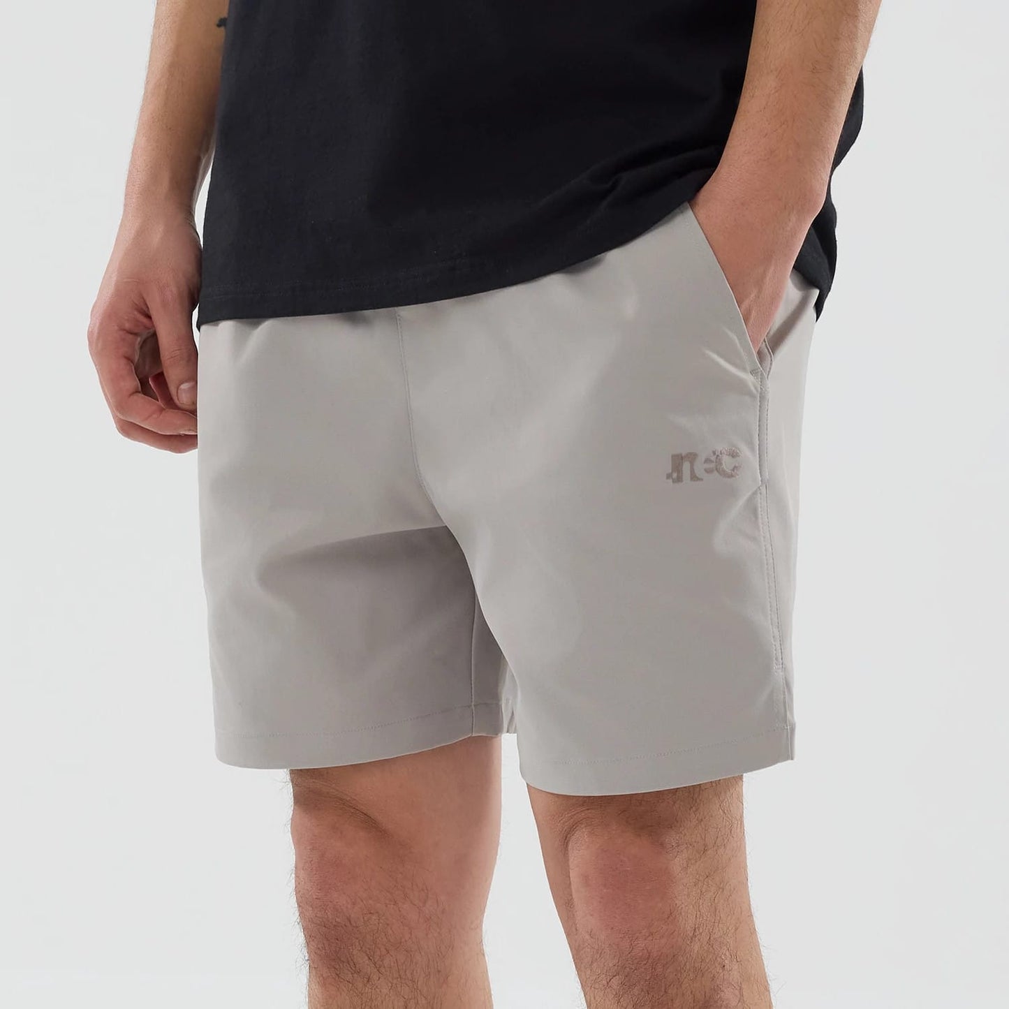 The model is wearing this New Era NEC Logo Oversized Shorts in Beige . 3