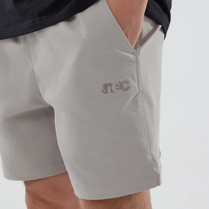 The model is wearing this New Era NEC Logo Oversized Shorts in Beige . 2
