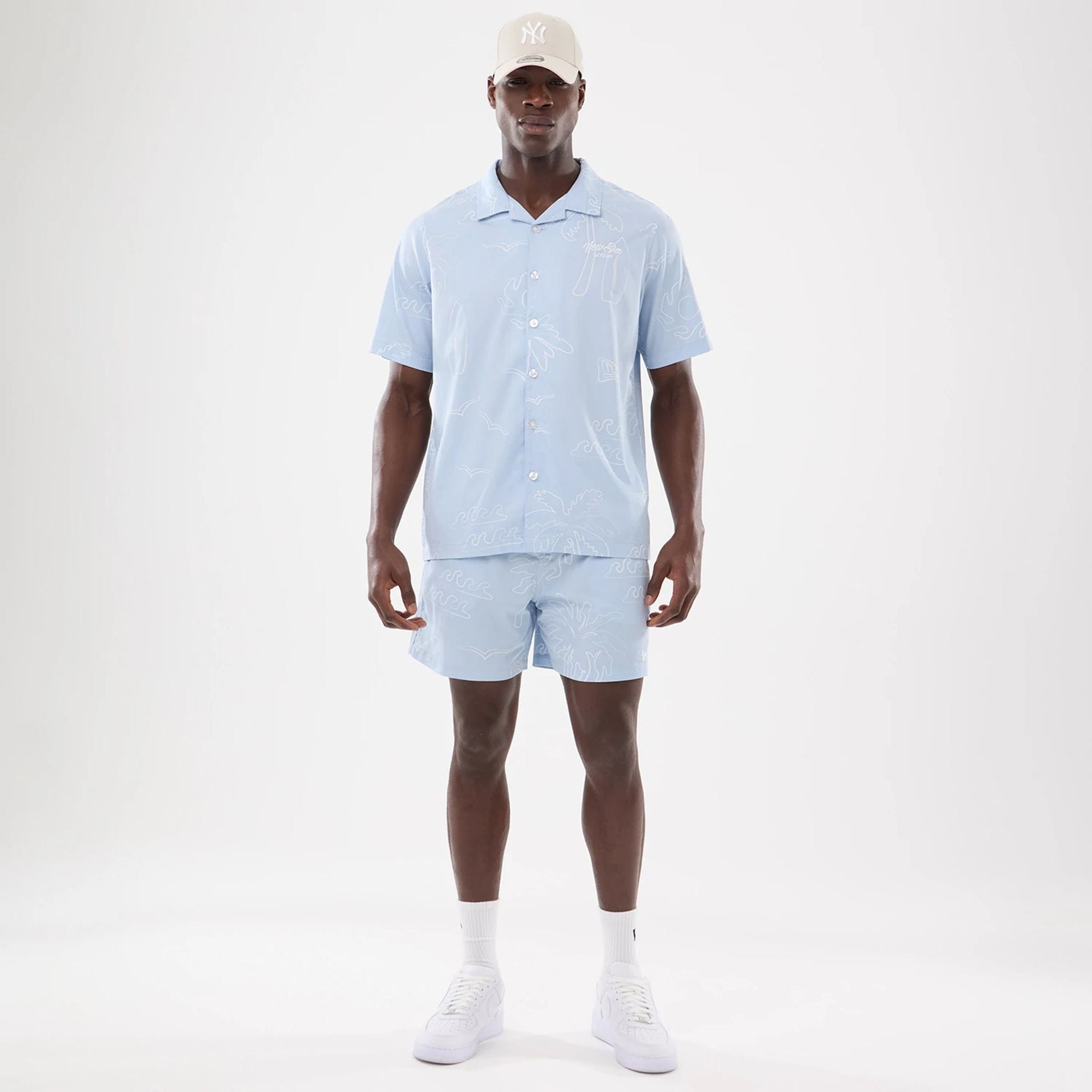 The model is wearing these New Era Resort Oversized Shorts in blue. 7