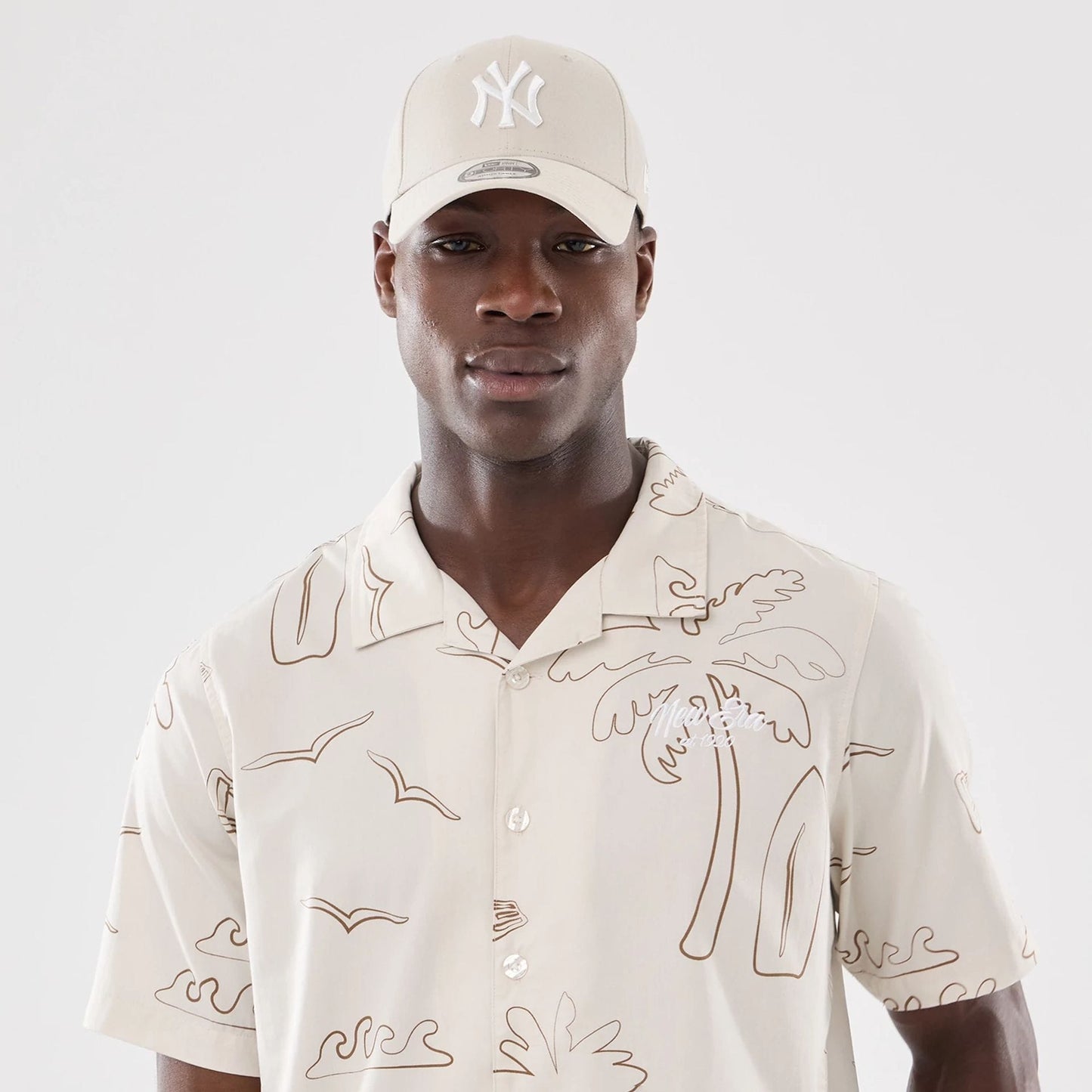 The model is wearing this New Era Resort Short Sleeve Shirt in natural. 7