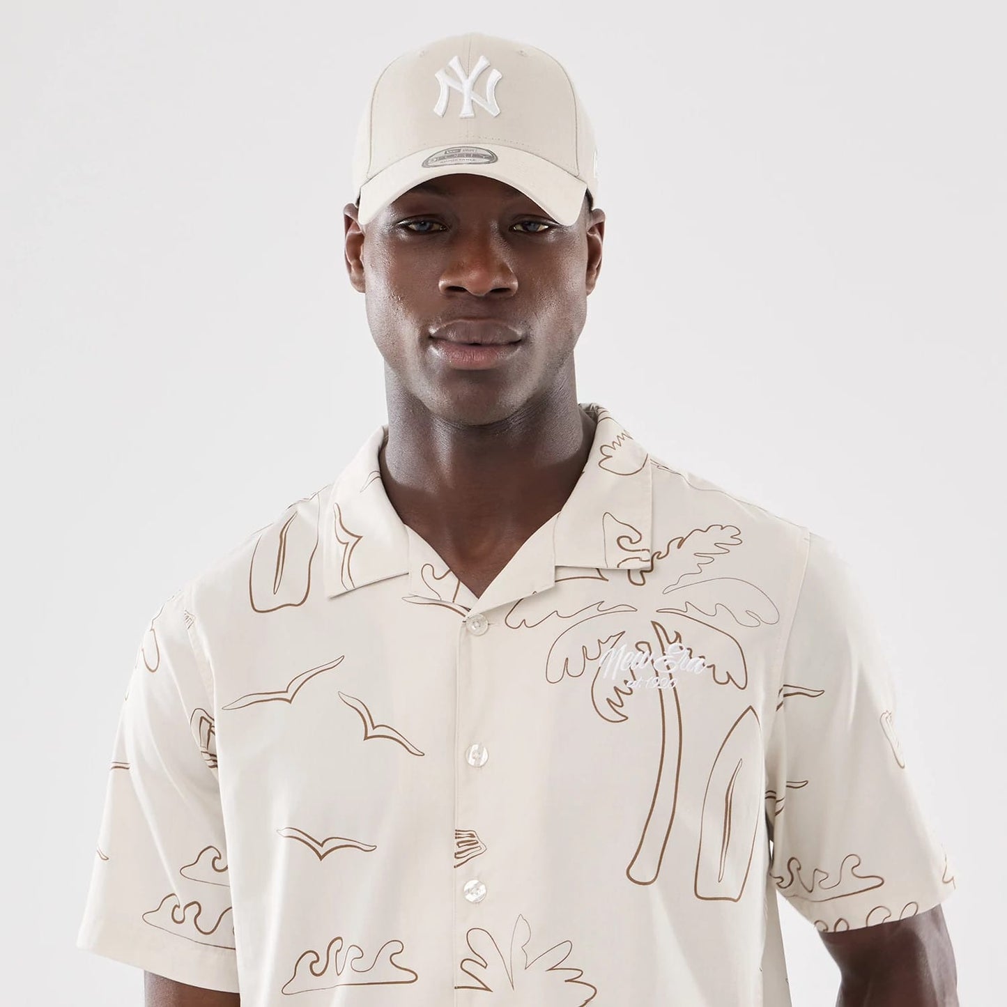 The model is wearing this New Era Resort Short Sleeve Shirt in natural. 7