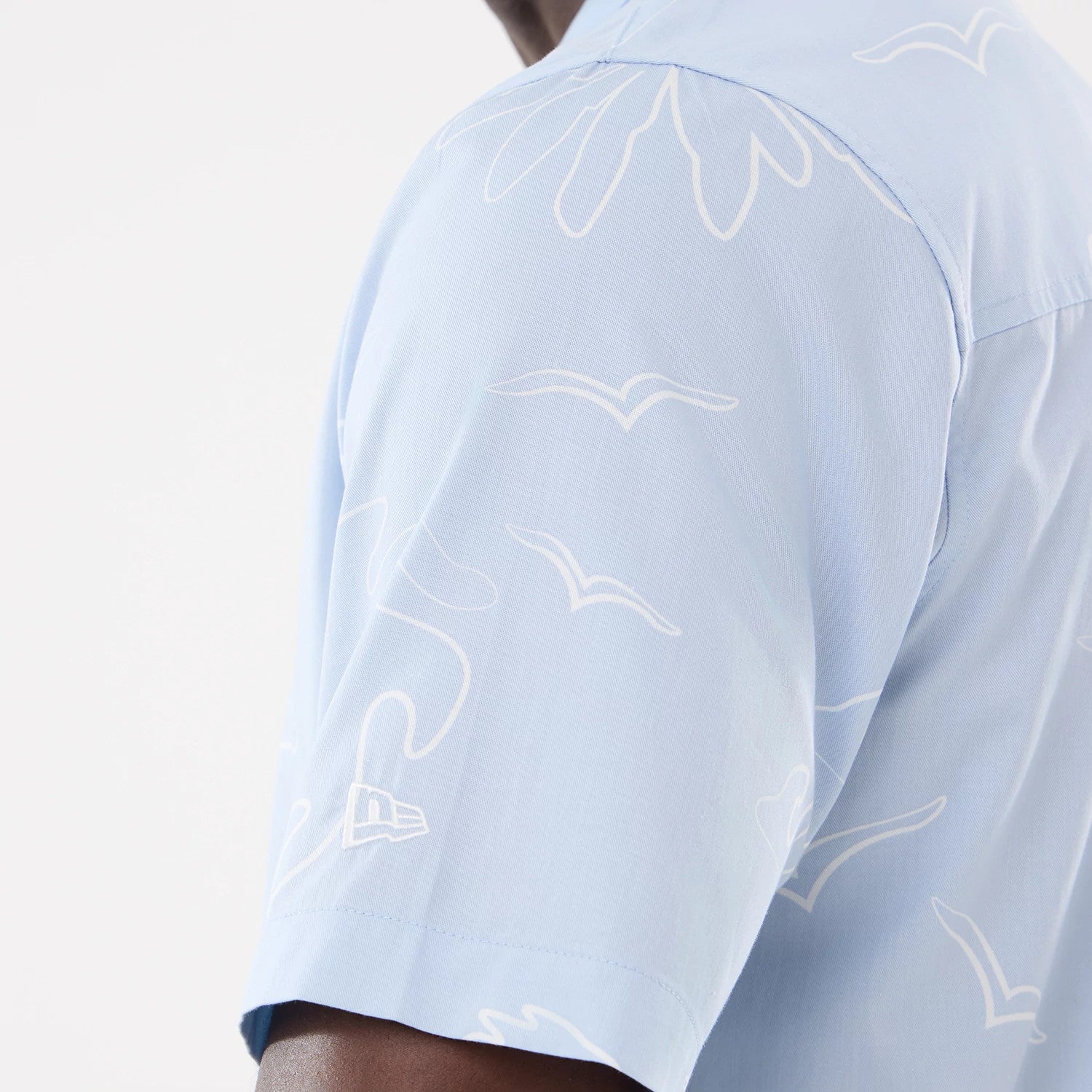 The model is wearing this New Era Resort Short Sleeve Shirt in blue. 4