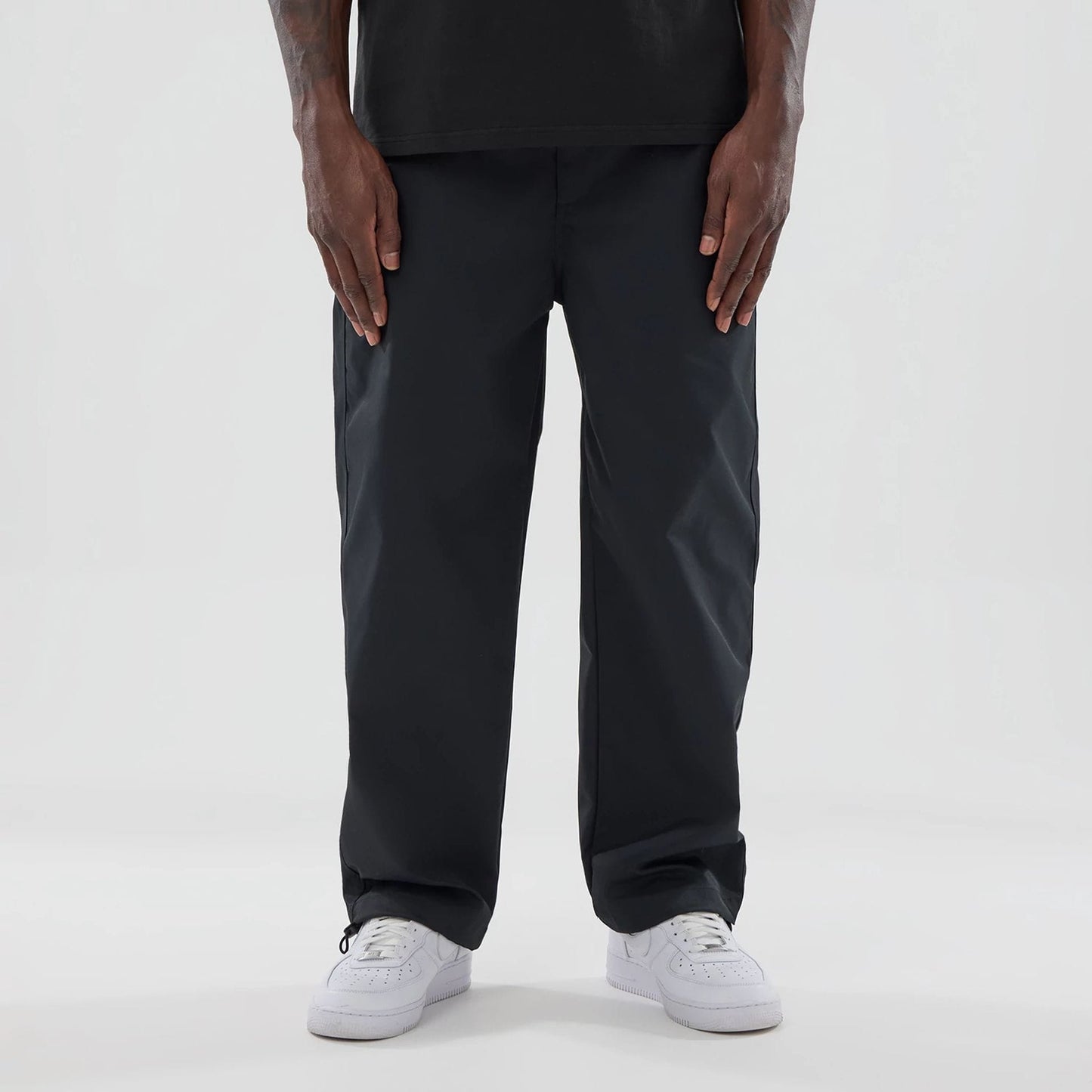 The model is wearing this New Era NEC Logo Straight Leg Joggers in black. 1