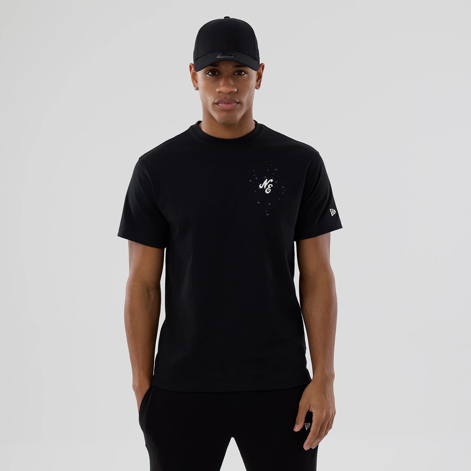 The model is wearing this New Era Zodiac Sign T-Shirt in black. 1