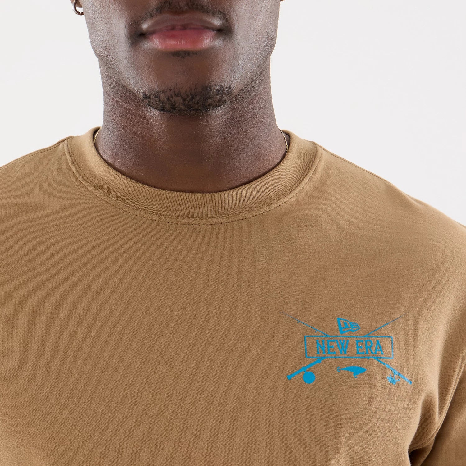 The model is wearing this New Era Outdoor Fishing T-Shirt in Beige. 6