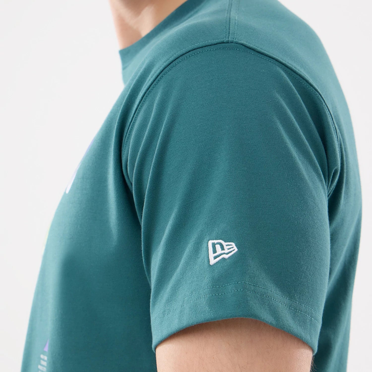 The model is wearing this New Era SK8 Graphic T-Shirt in dark green. 4