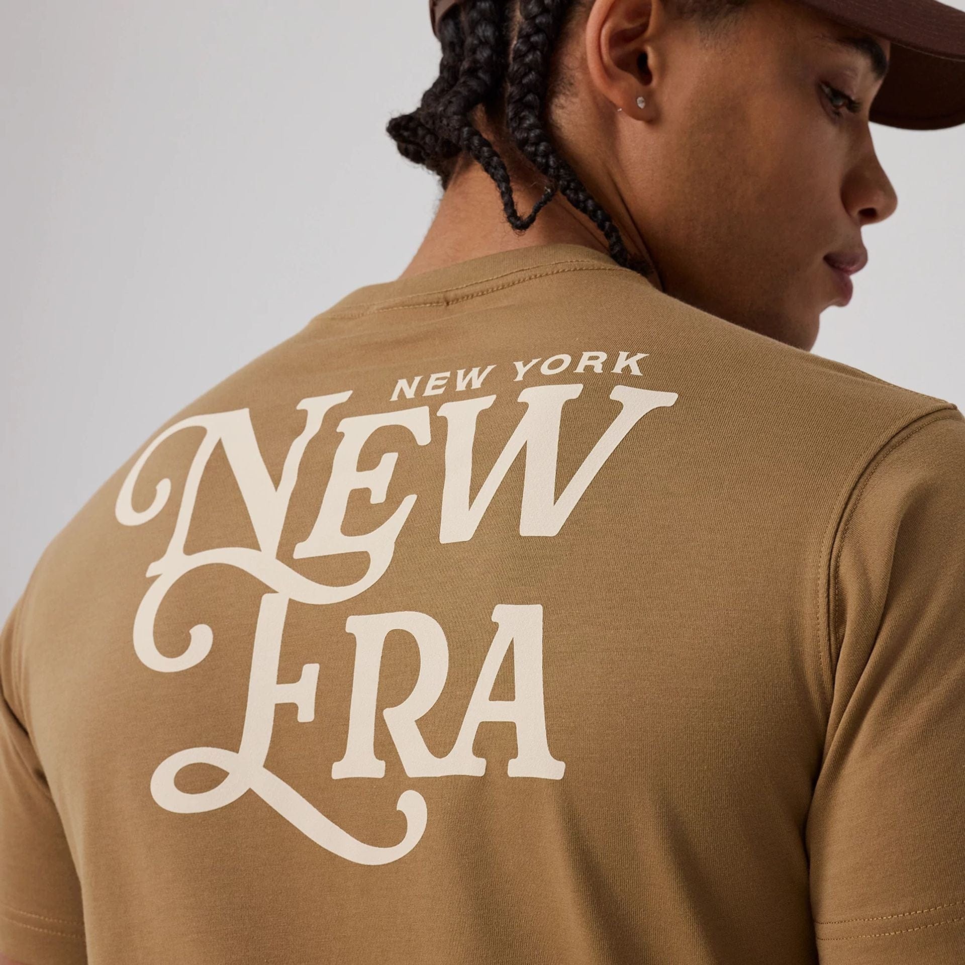 The model is wearing this New Era Script Graphic T-Shirt in Beige. 4