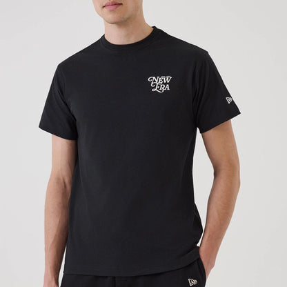 The model is wearing this New Era Script Graphic T-Shirt in black. 4