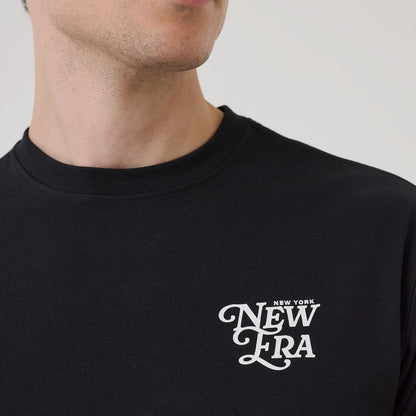 The model is wearing this New Era Script Graphic T-Shirt in black. 6