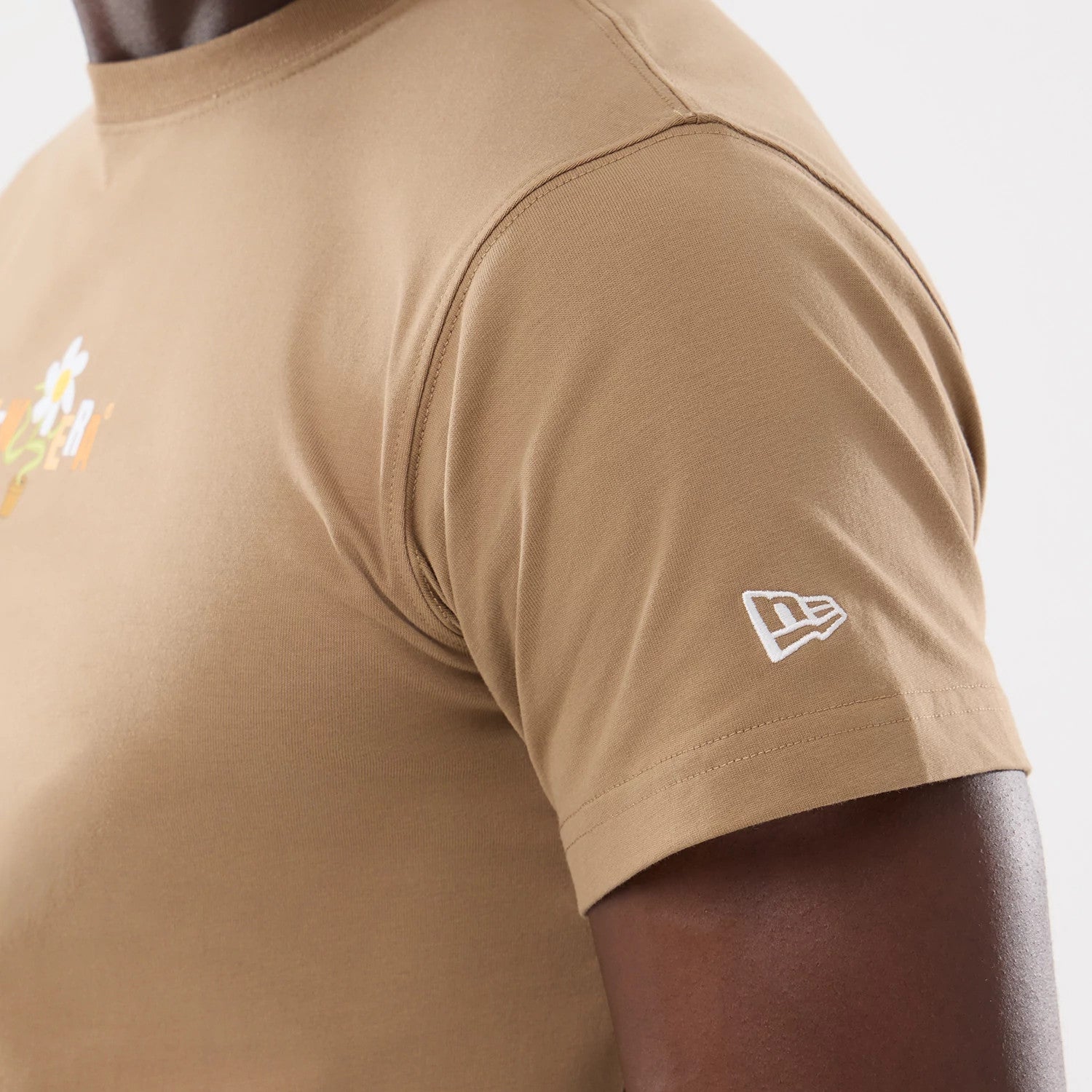 The model is wearing this New Era Earth Day T-Shirt in beige/khaki. 4