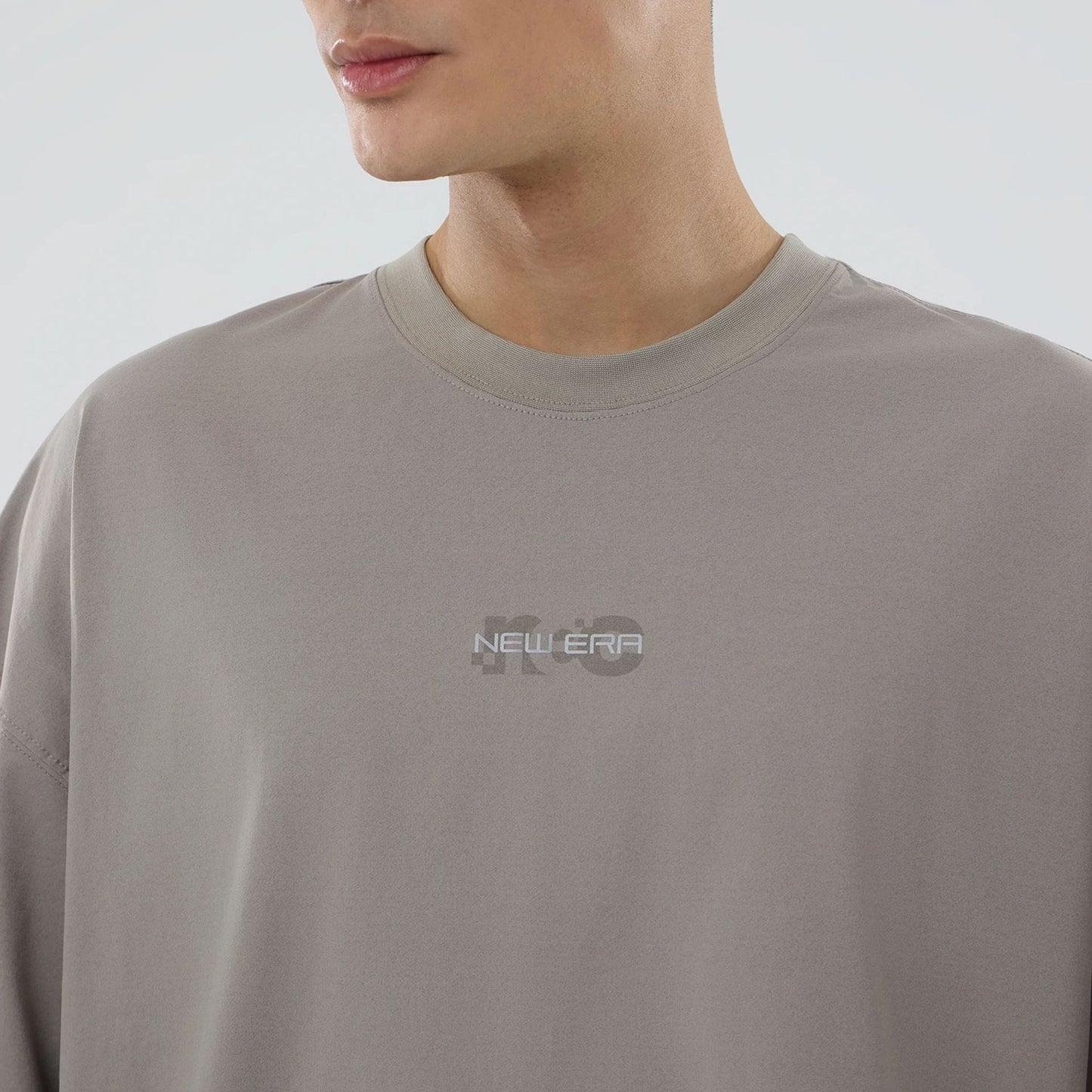 The model is wearing this New Era NEC Logo Oversized T-Shirt in Beige. 3