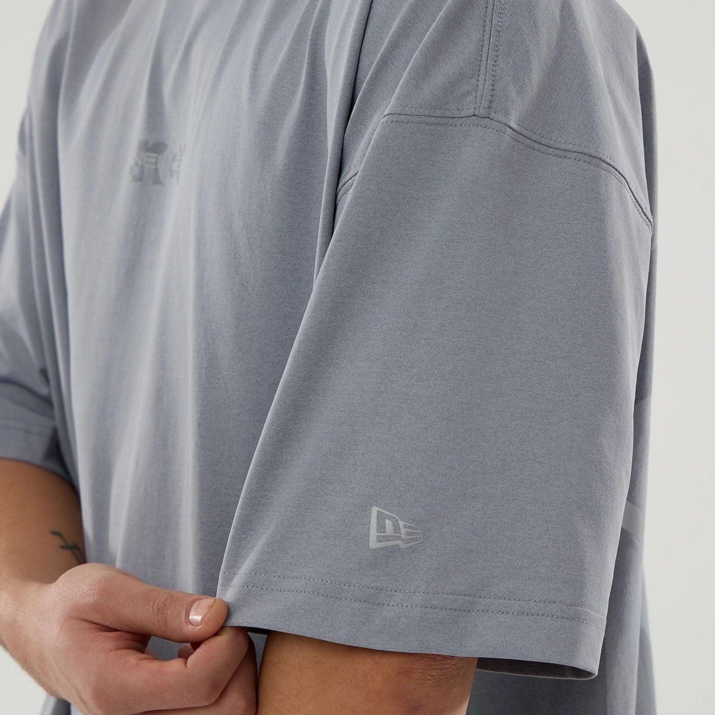 The model is wearing this New Era Urban Core Oversized T-Shirt in grey. 5