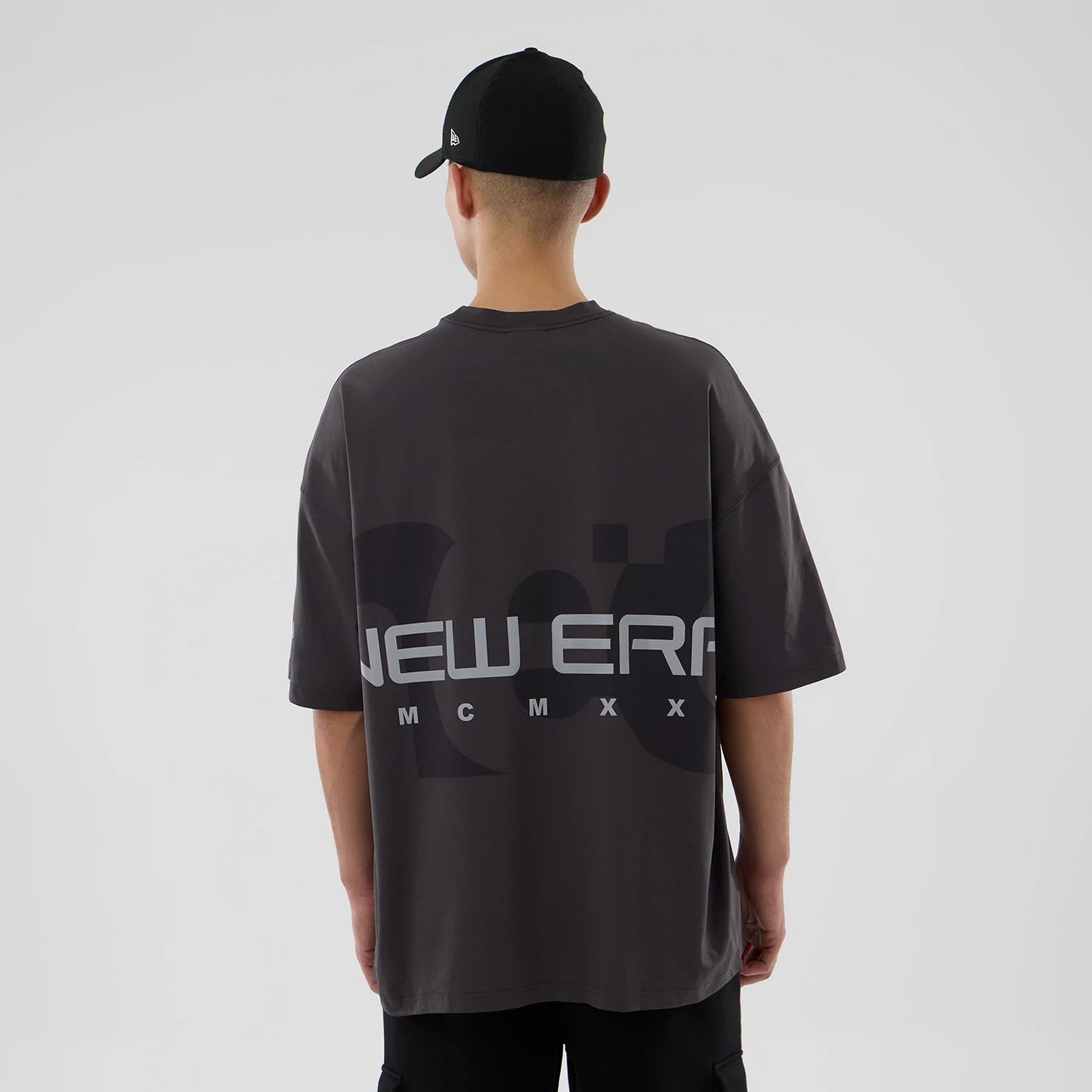 The model is wearing this New Era NEC Logo Oversized T-Shirt in black. 2