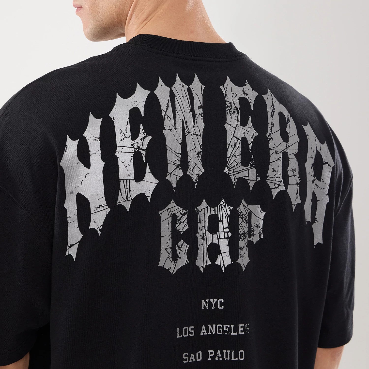 The model is wearing this New Era Street Archived City Oversized T-Shirt in black. 7