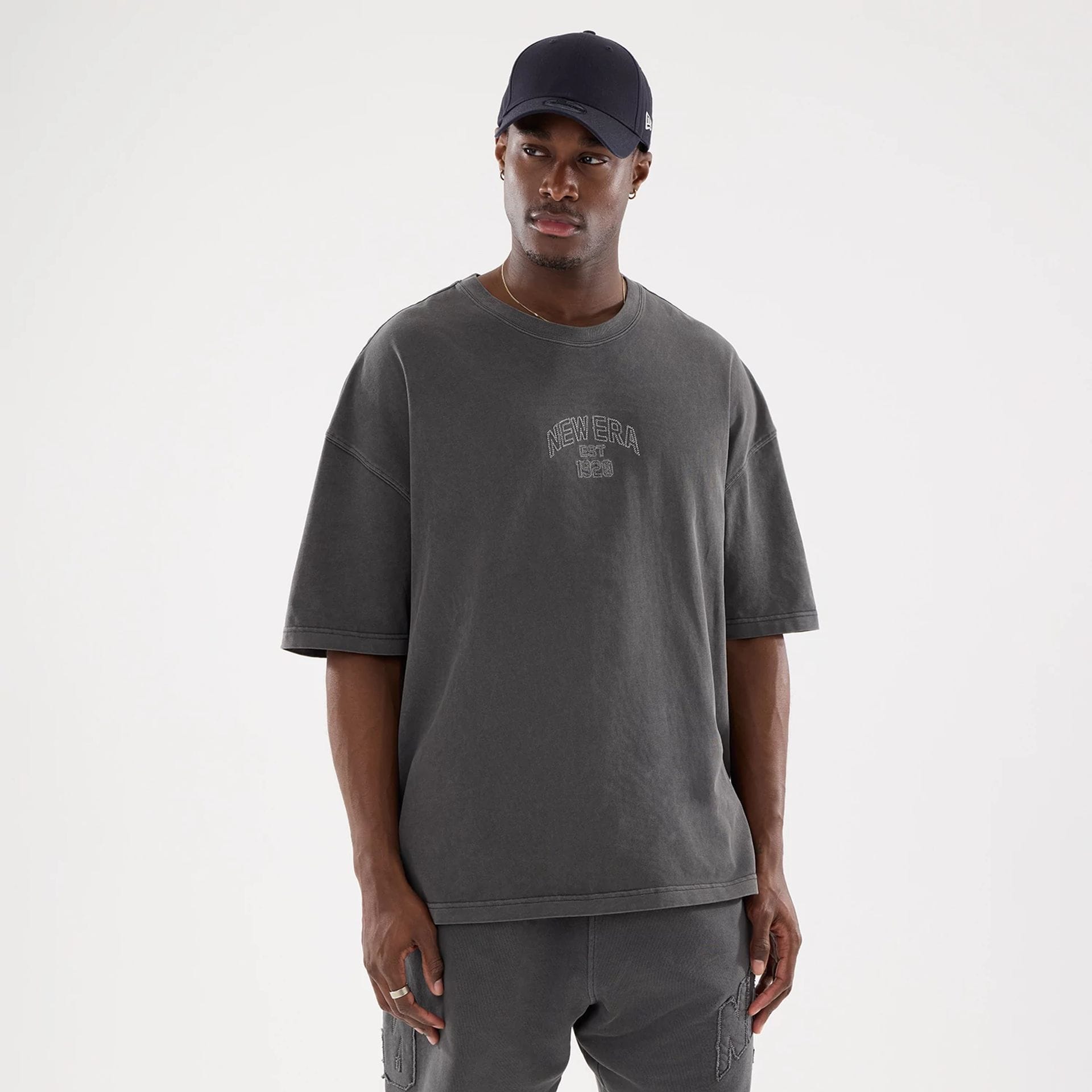 The model is wearing this New Era Street Archived Oversized T-Shirt in black. 1