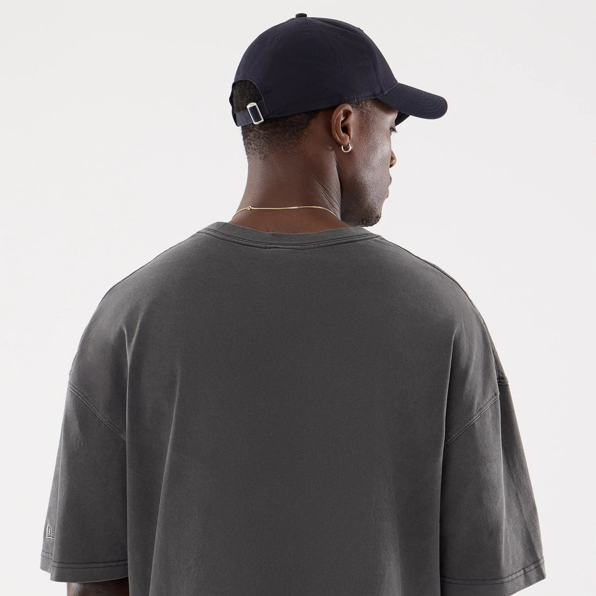 The model is wearing this New Era Street Archived Oversized T-Shirt in black. 7