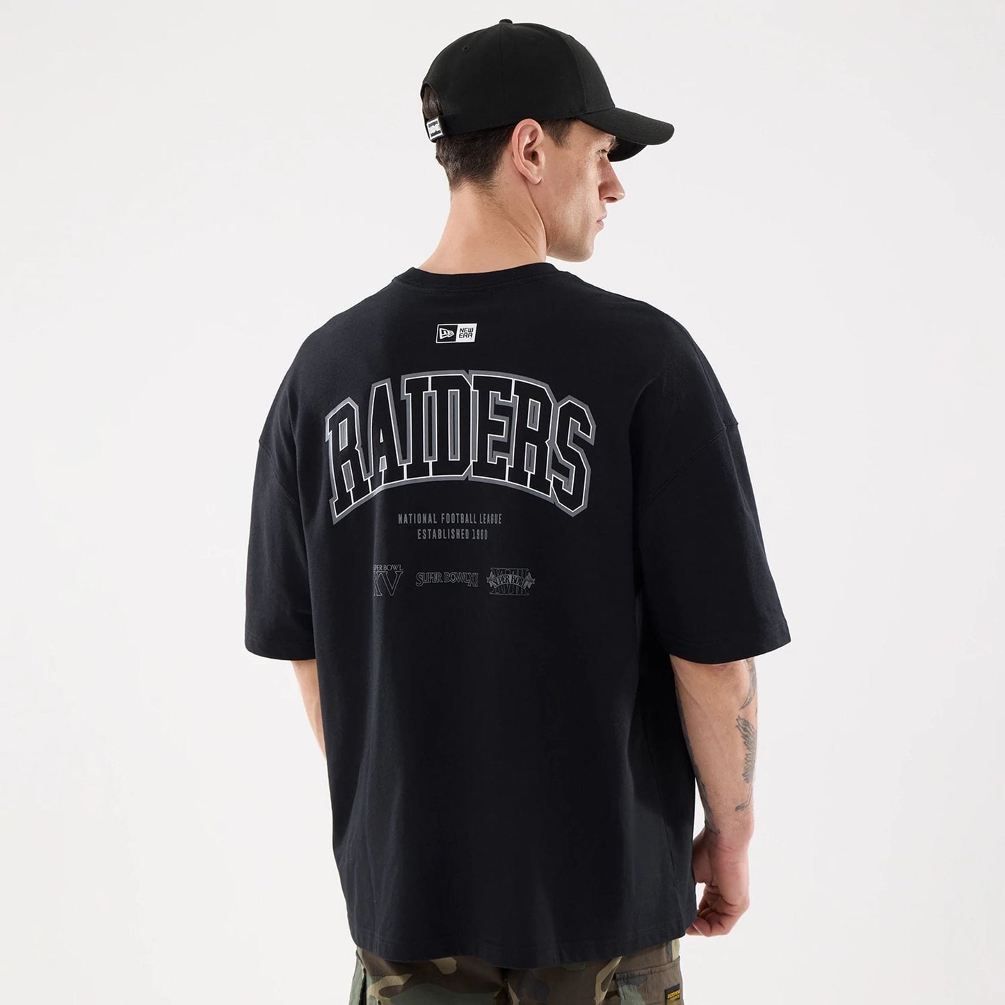 The model is wearing this NFL Raiders Wear Las Vegas Raiders Oversized T-Shirt in black. 2