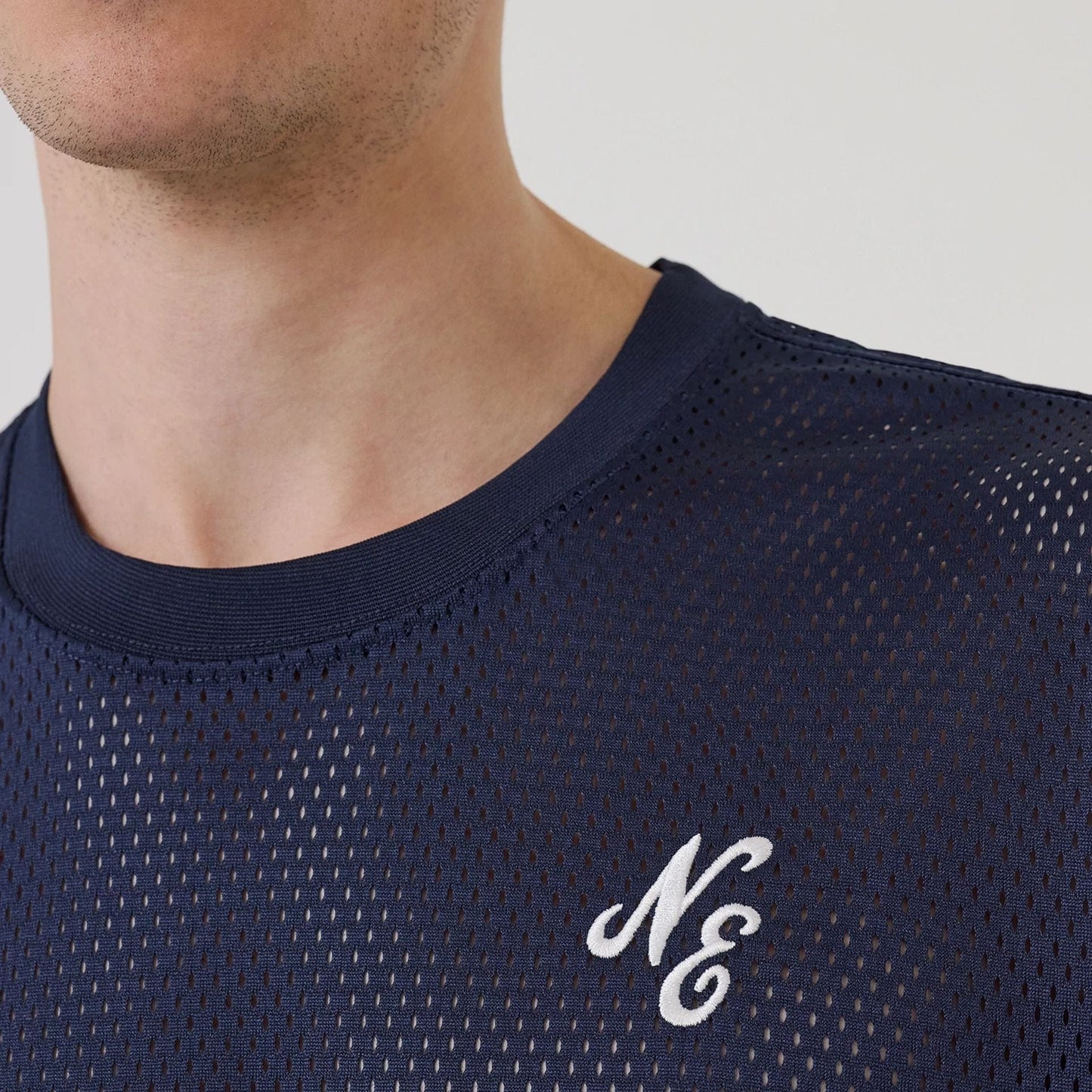 The model is wearing this New Era Mix League Oversized Mesh T-Shirt in blue. 5