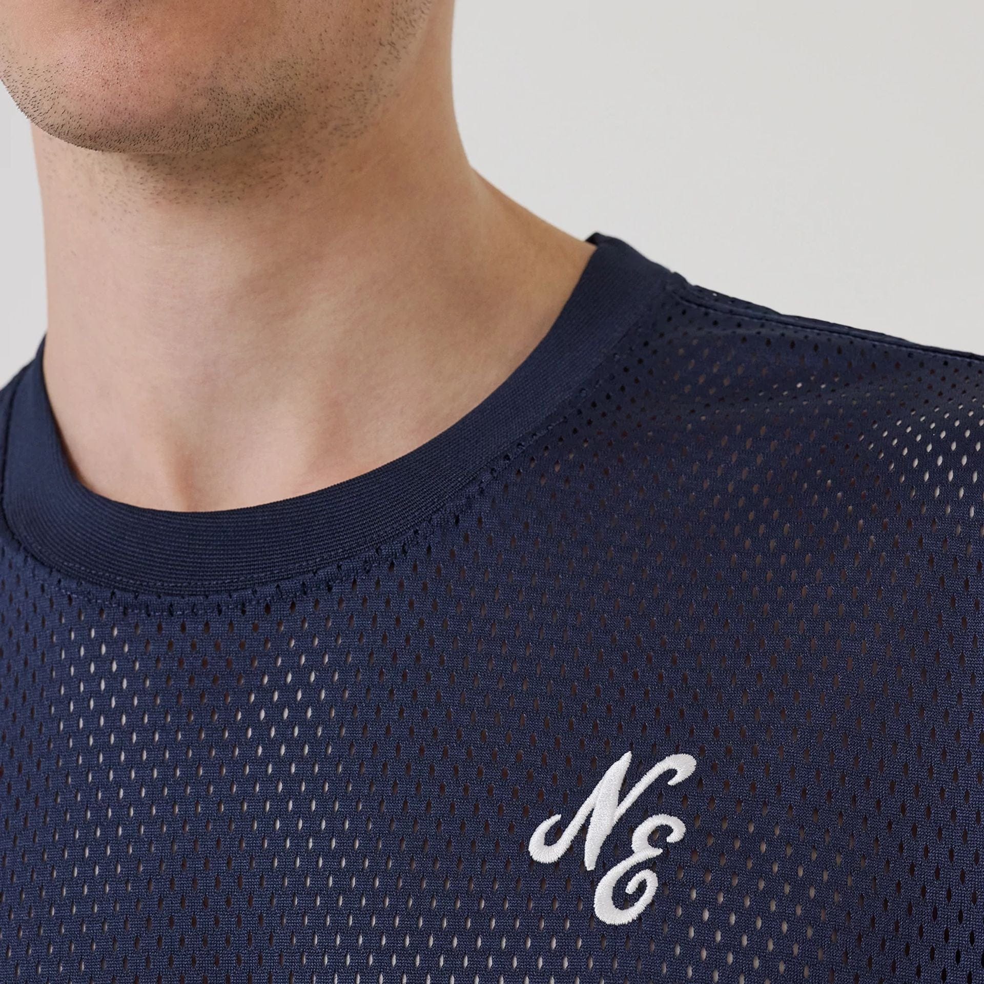 The model is wearing this New Era Mix League Oversized Mesh T-Shirt in blue. 5