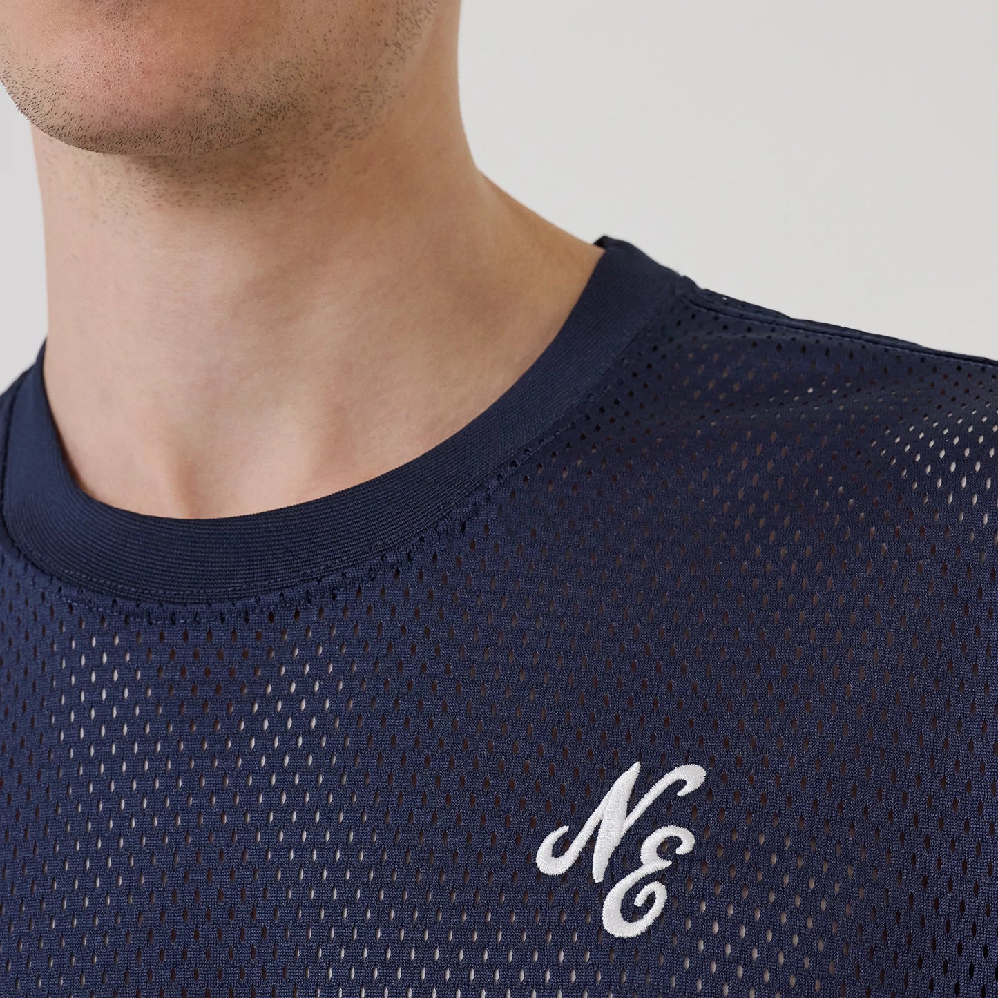 The model is wearing this New Era Mix League Oversized Mesh T-Shirt in blue. 5