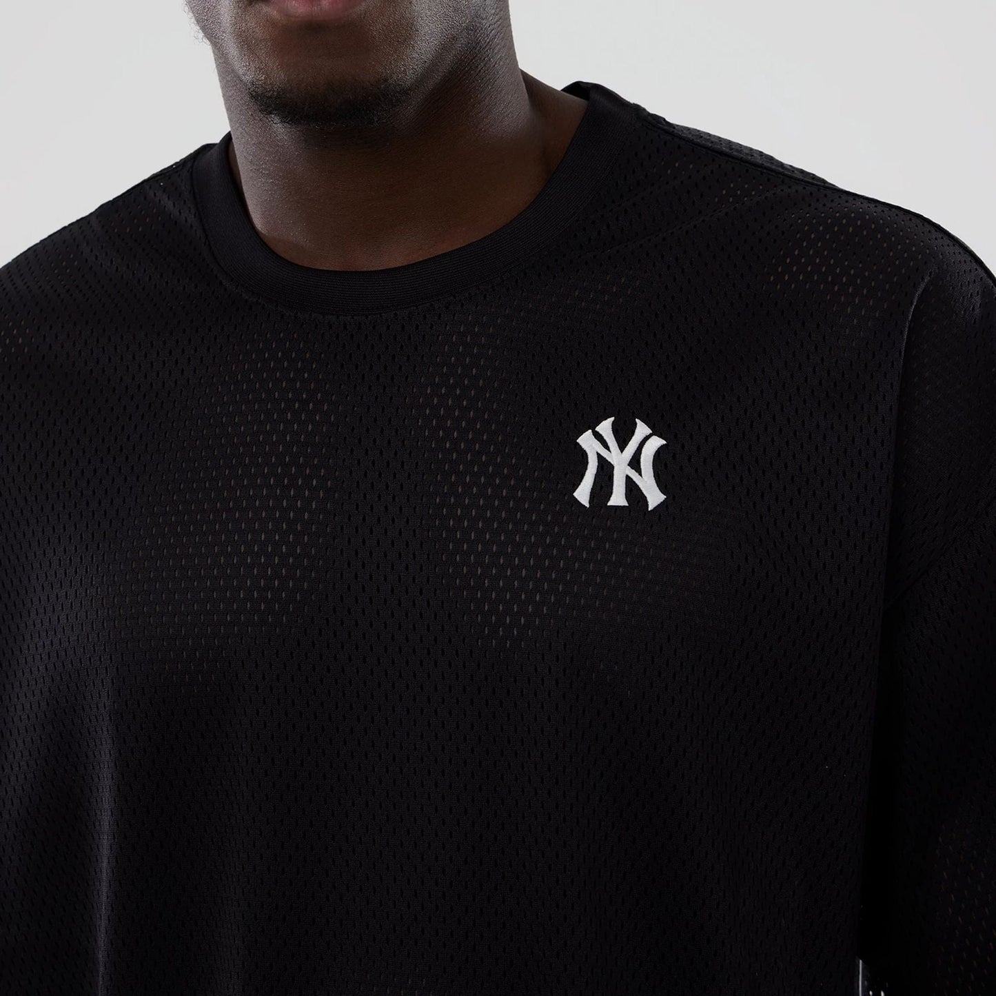 The model is wearing this MLB Mix League New York Yankees Oversized Mesh T-Shirt in black. 5