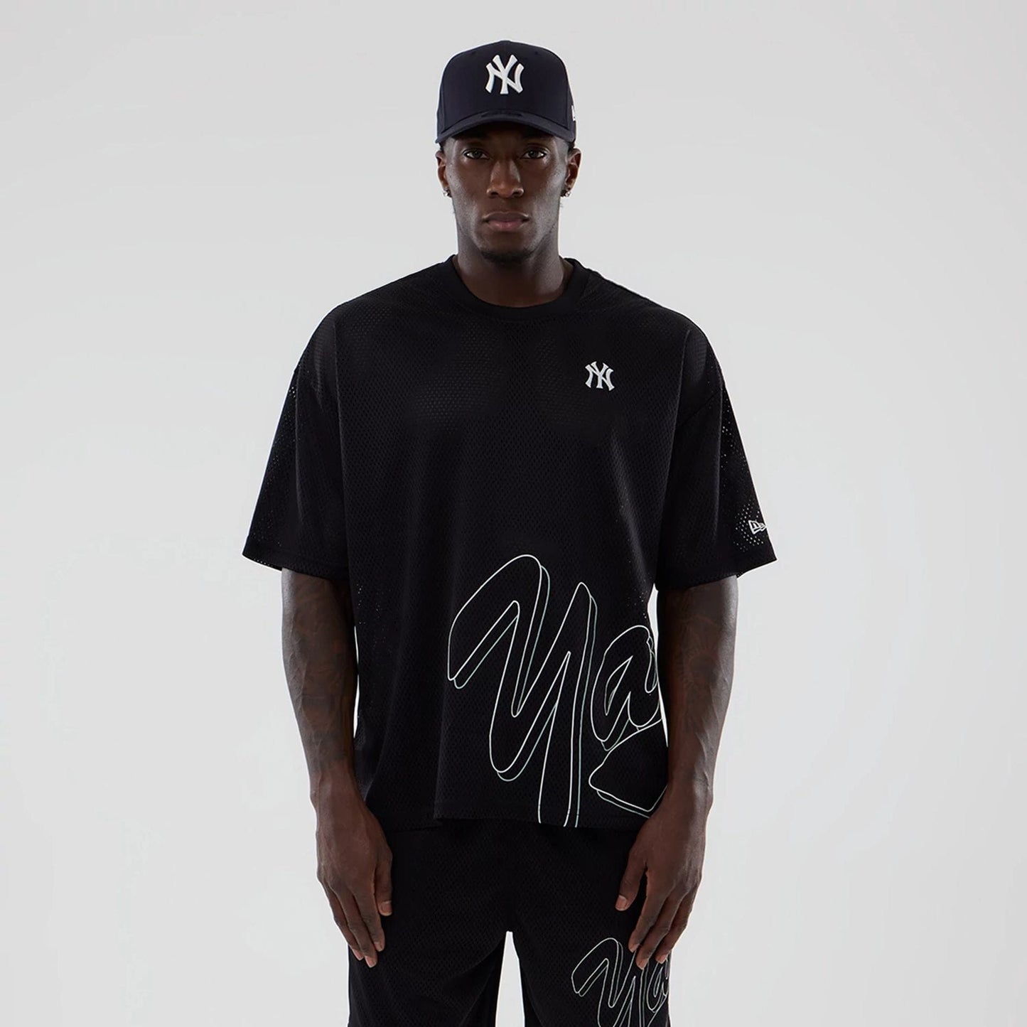 The model is wearing this MLB Mix League New York Yankees Oversized Mesh T-Shirt in black. 1