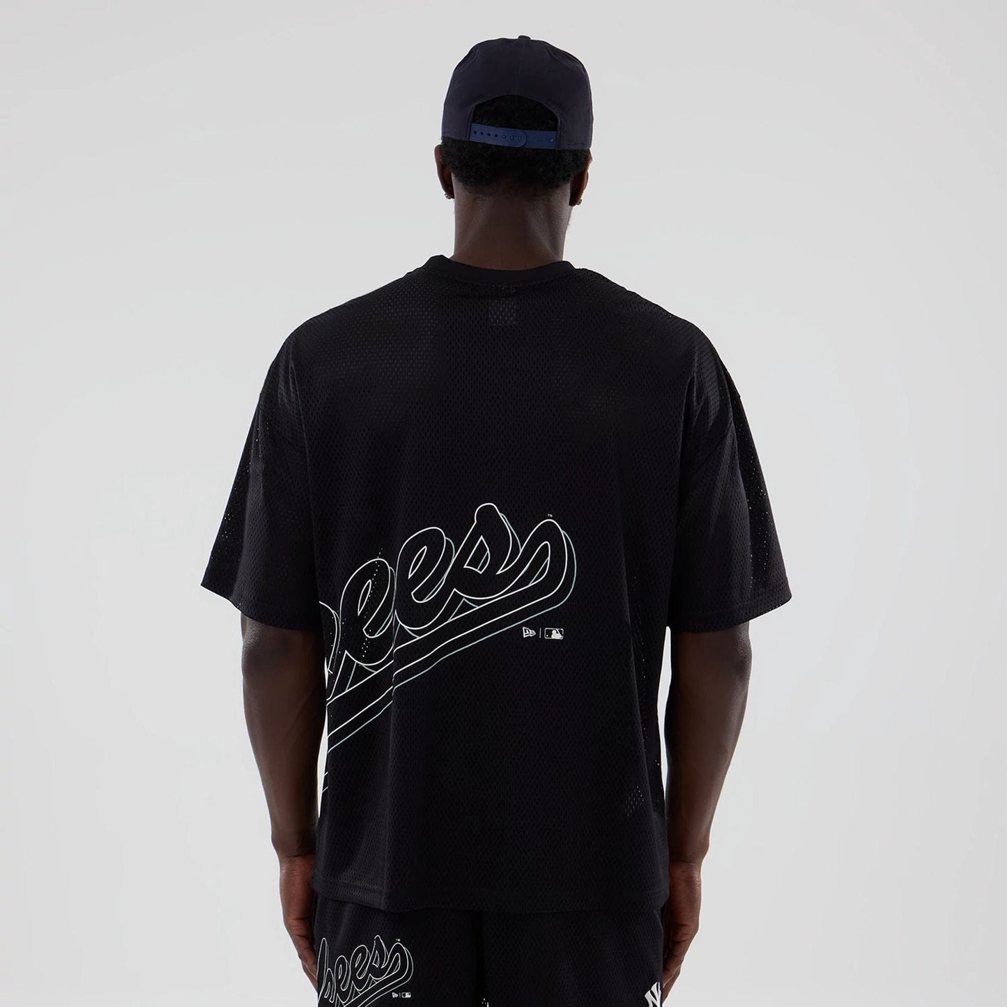 The model is wearing this MLB Mix League New York Yankees Oversized Mesh T-Shirt in black. 2