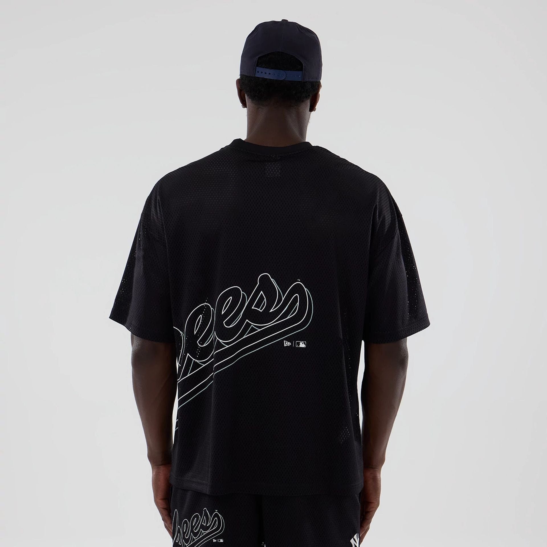 The model is wearing this MLB Mix League New York Yankees Oversized Mesh T-Shirt in black. 2