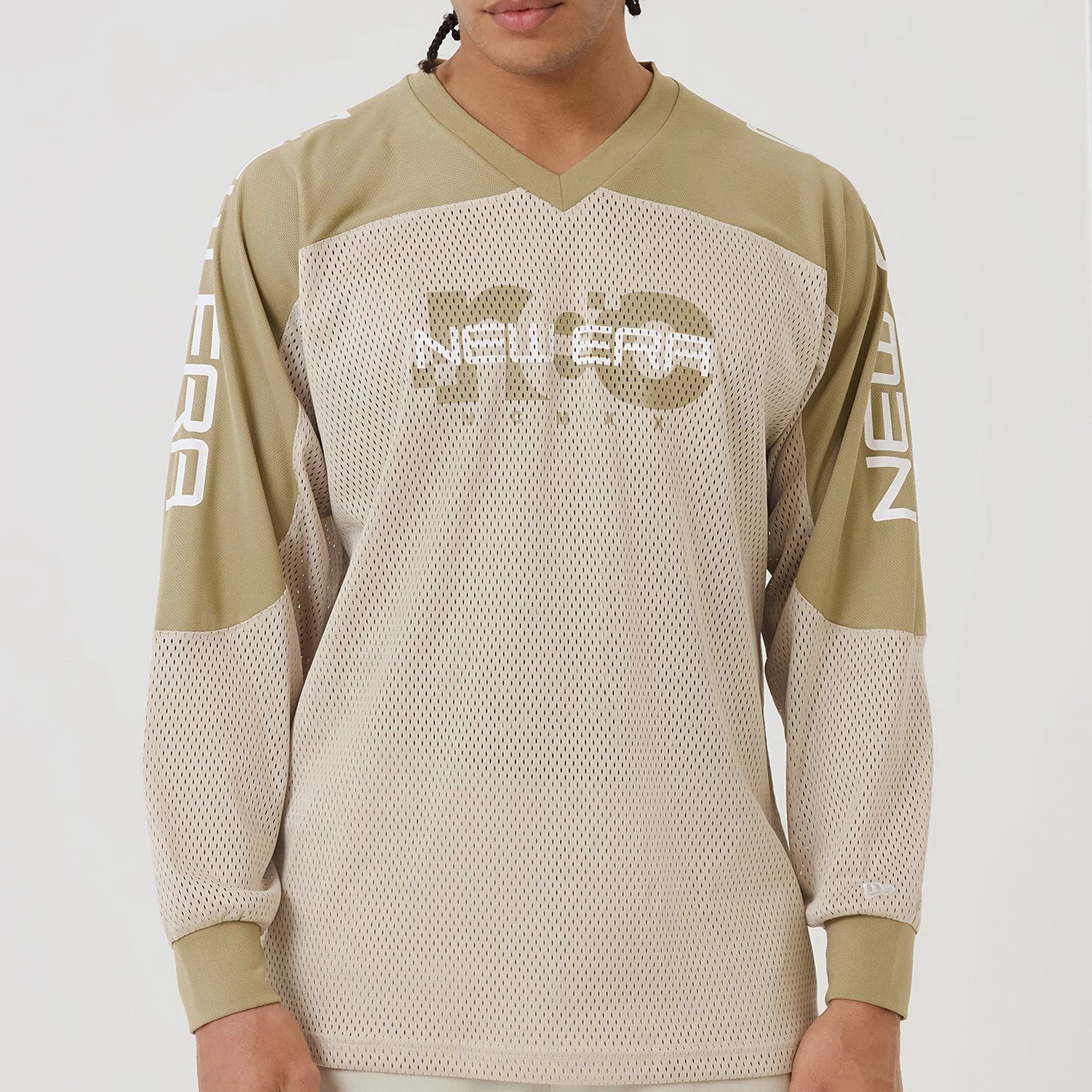 The model is wearing this New Era NEC Logo Long Sleeve Jersey in beige/khaki. 3