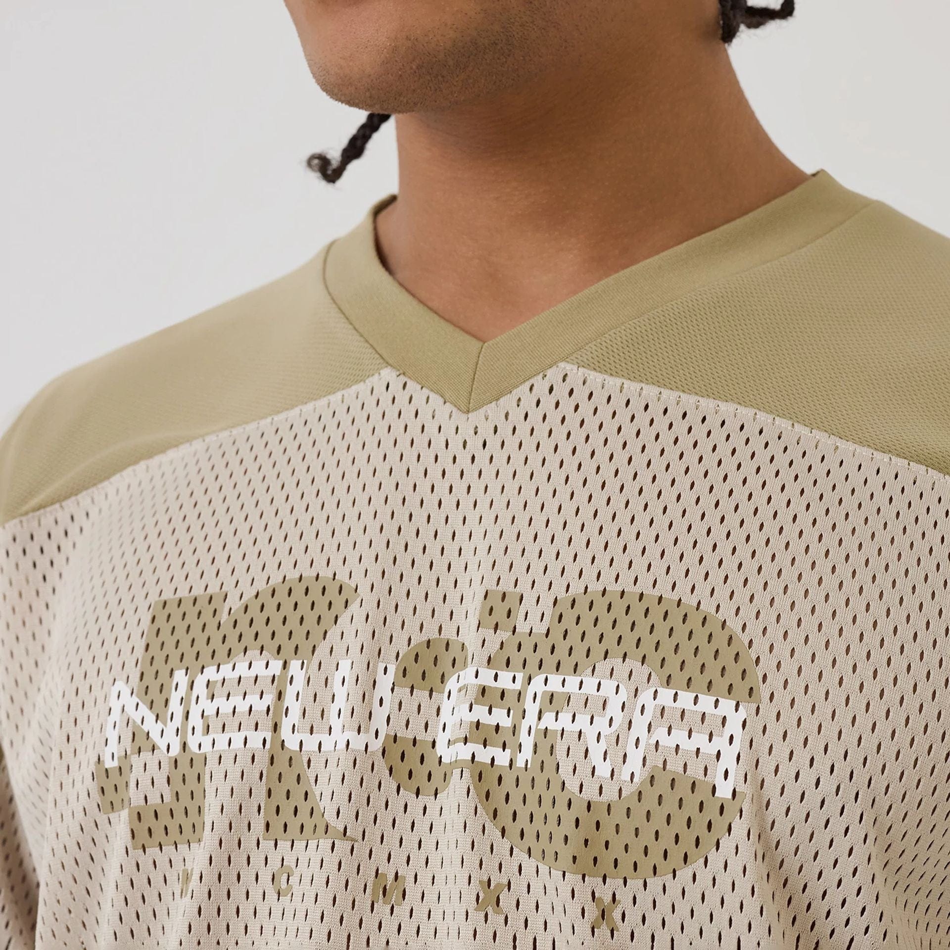 The model is wearing this New Era NEC Logo Long Sleeve Jersey in beige/khaki. 5