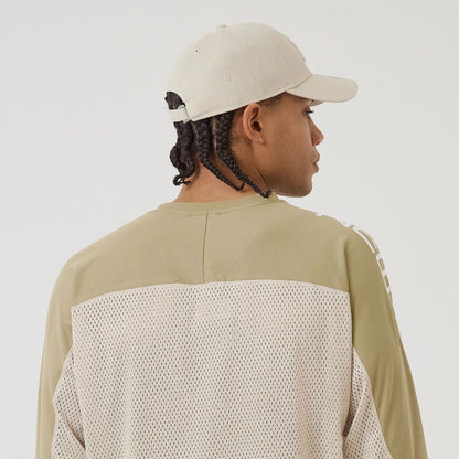 The model is wearing this New Era NEC Logo Long Sleeve Jersey in beige/khaki. 7