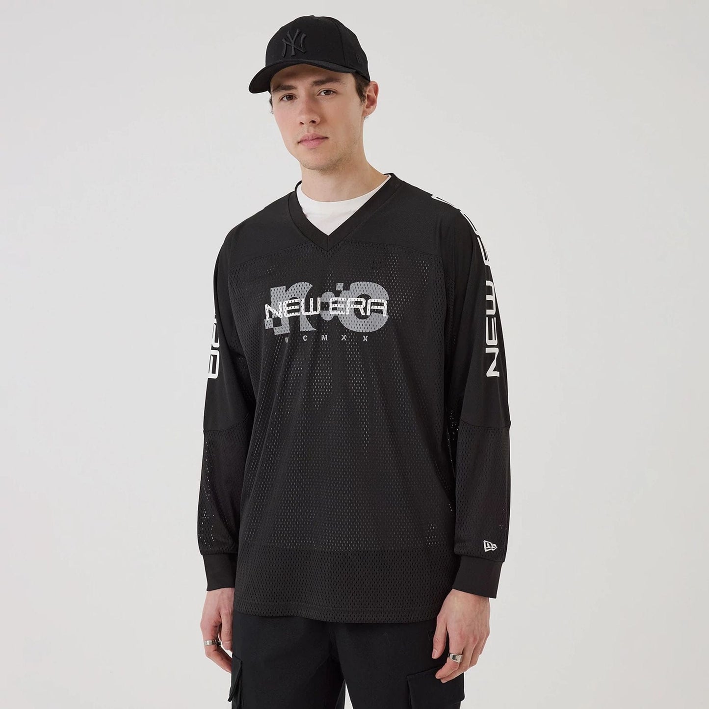 The model is wearing this New Era NEC Logo Long Sleeve Jersey in black. 1